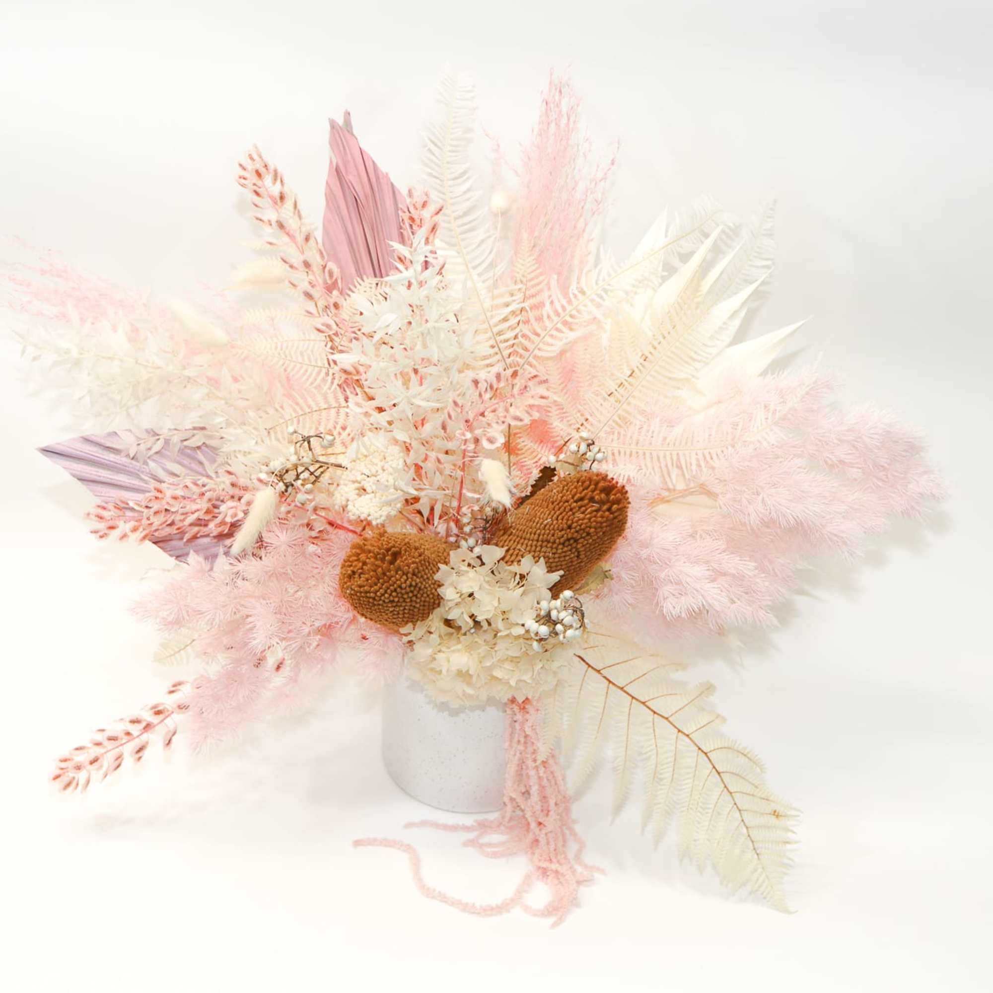 Pastel dried floral arrangement in a white vase