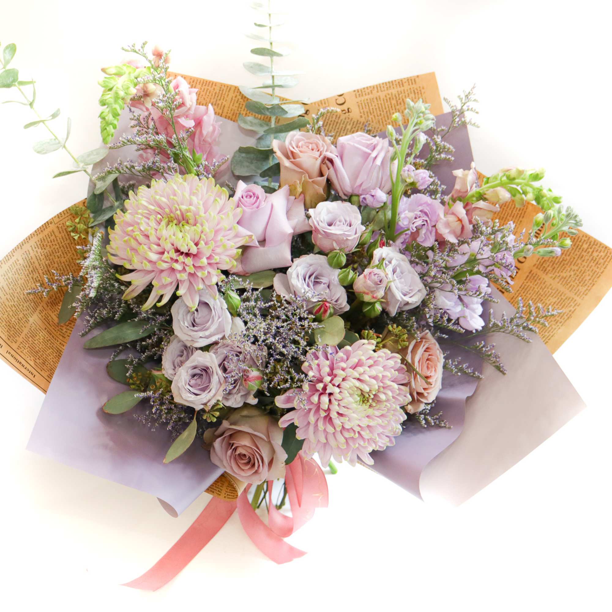 Bouquet of pastel roses and chrysanthemums wrapped in paper