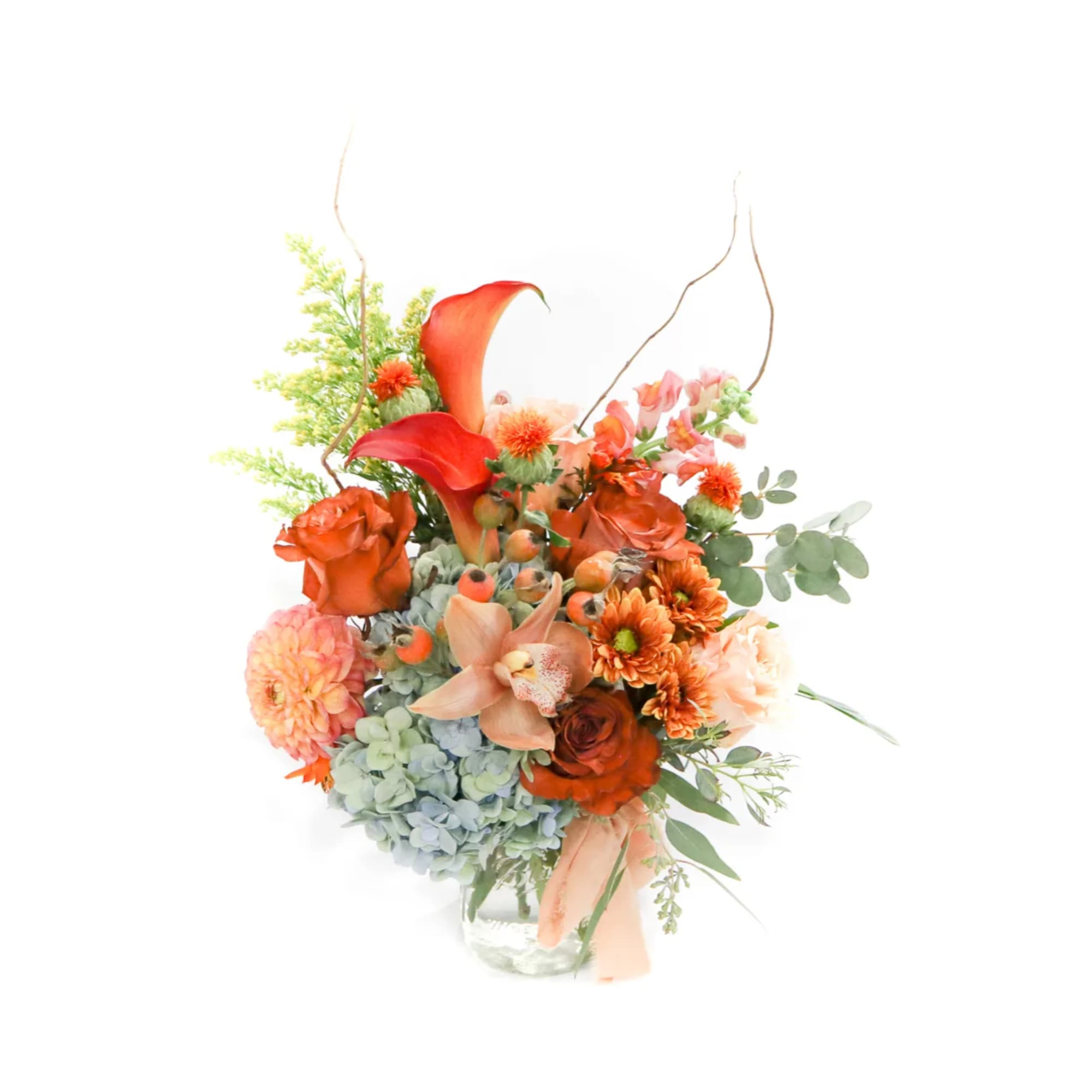 Orange floral arrangement in a clear glass vase with calla lilies and roses