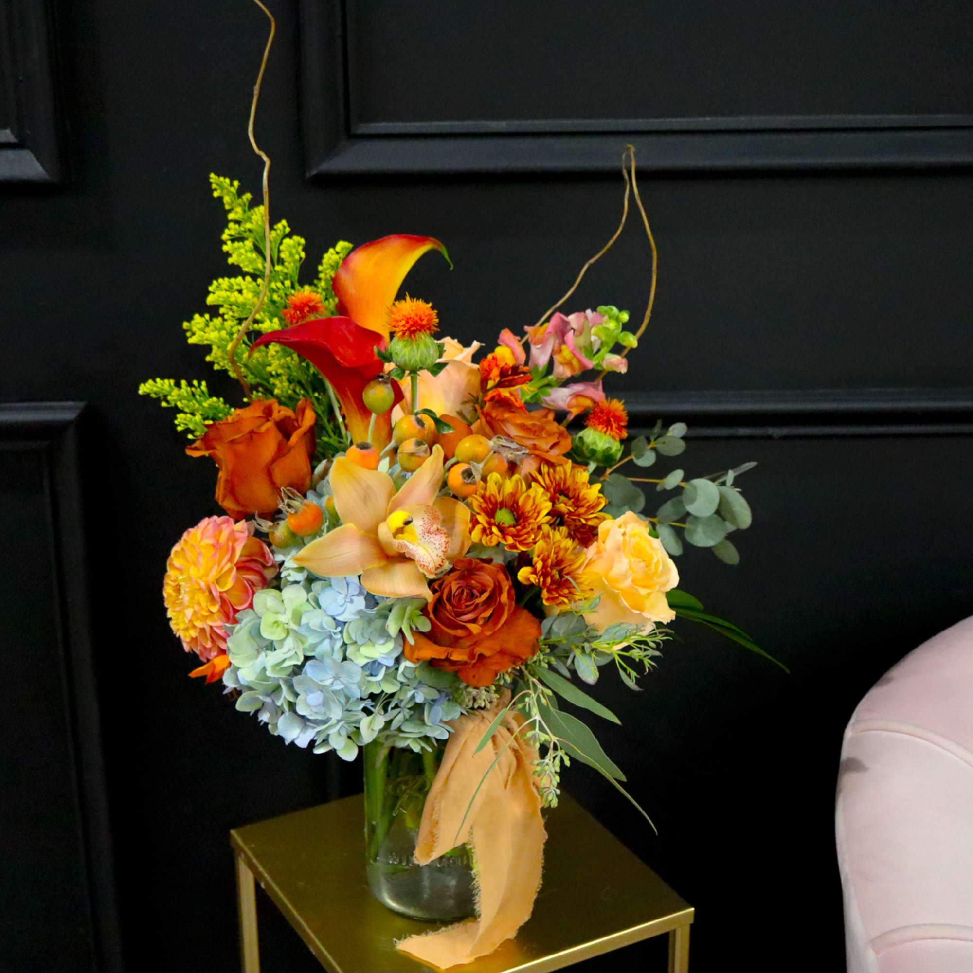 Orange and yellow floral arrangement in a glass vase