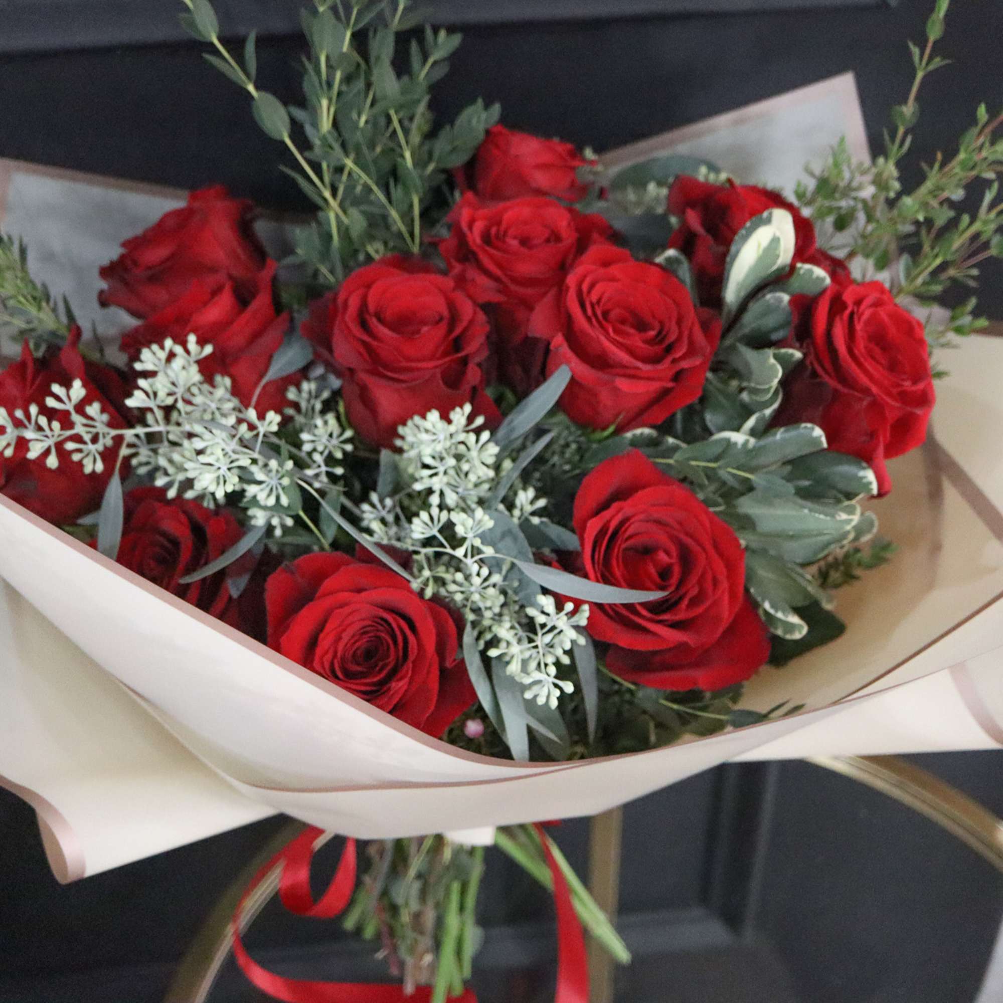 Bouquet of red roses wrapped in cream paper