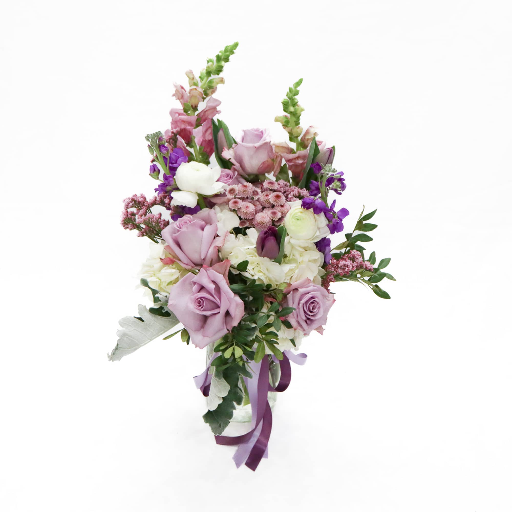 Lavender Whisper is an elegant front-facing floral arrangement designed in a clear