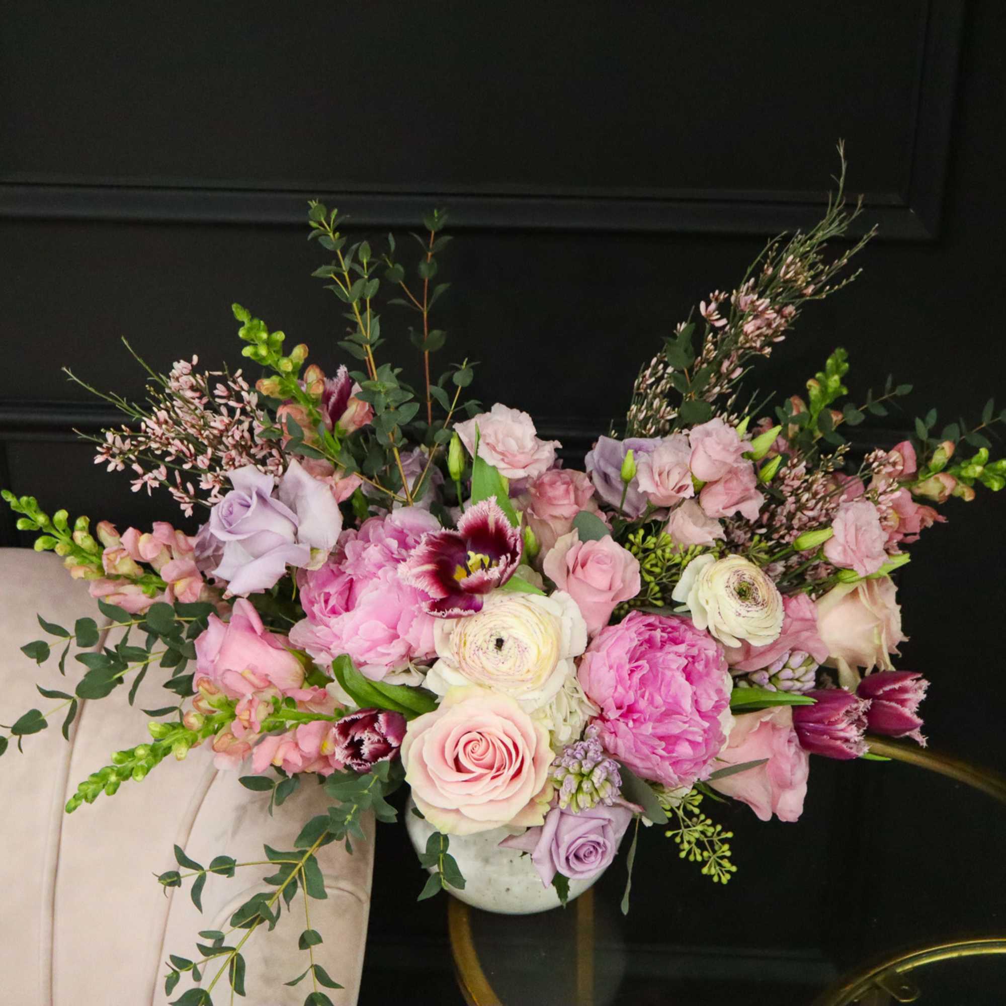 Pink and lavender floral arrangement in a white vase