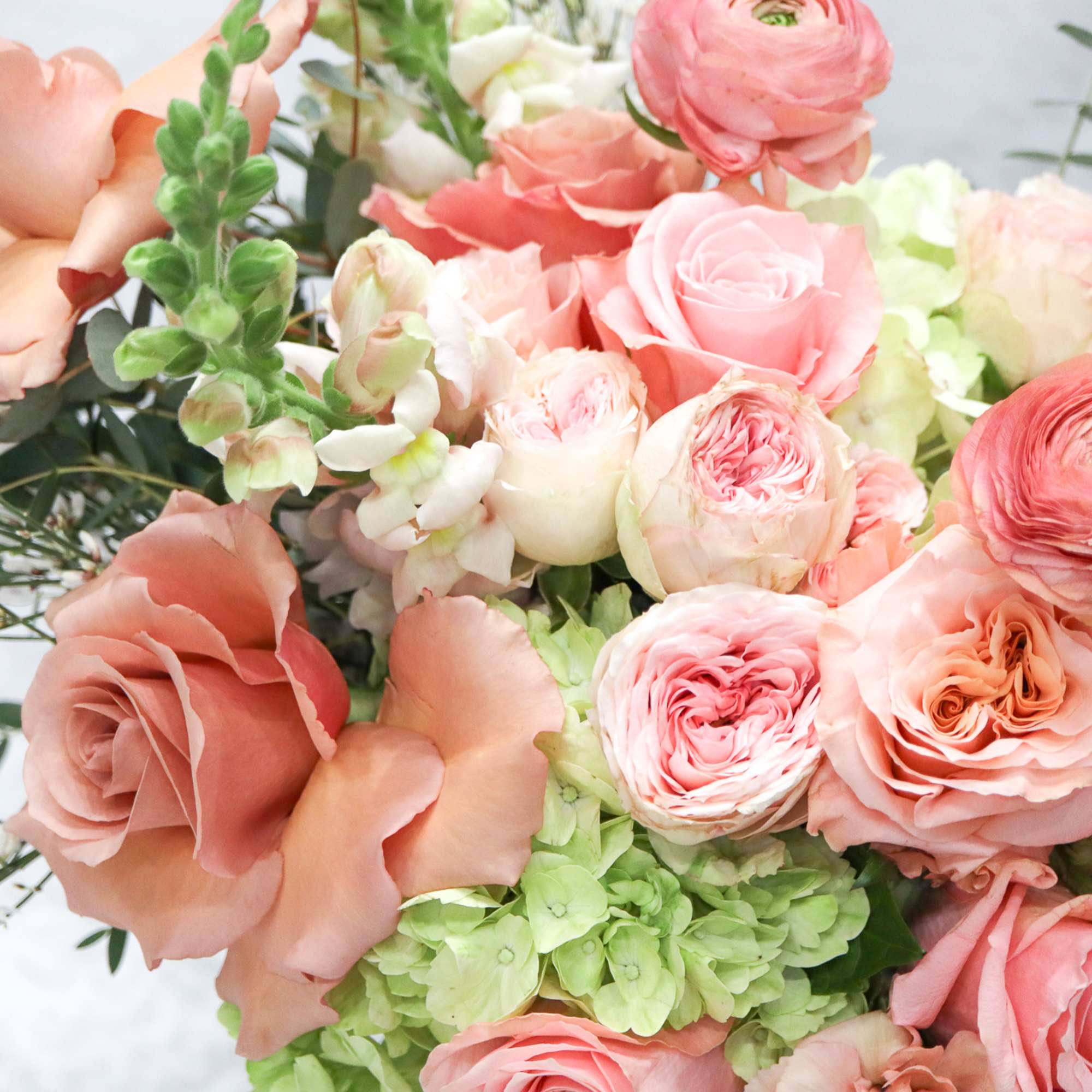 Bouquet of peach and pink roses with green hydrangeas