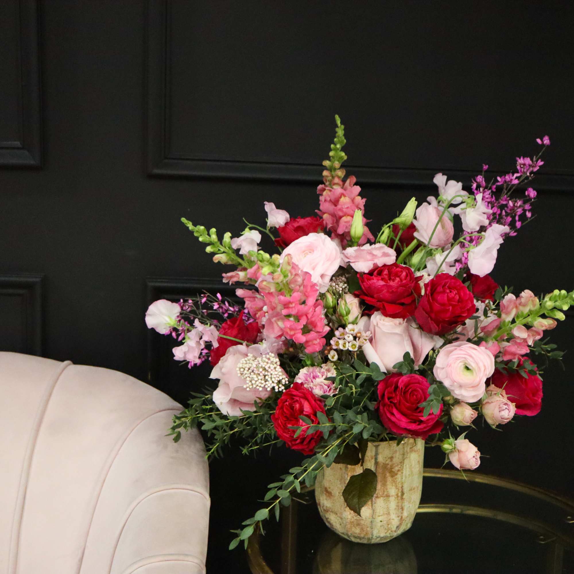 Bouquet of red and pink flowers in a ceramic vase