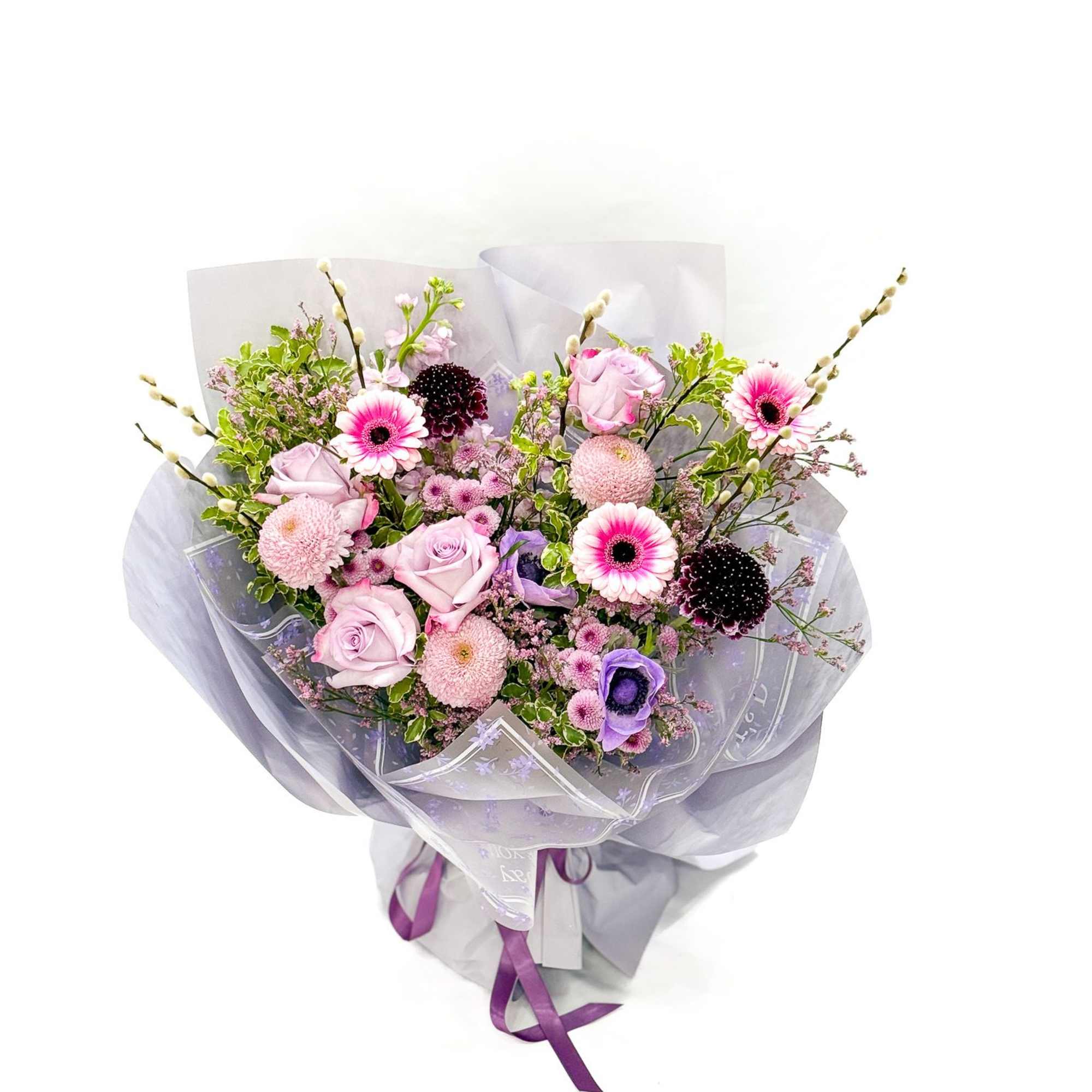 Bouquet of pink and purple flowers wrapped in translucent paper