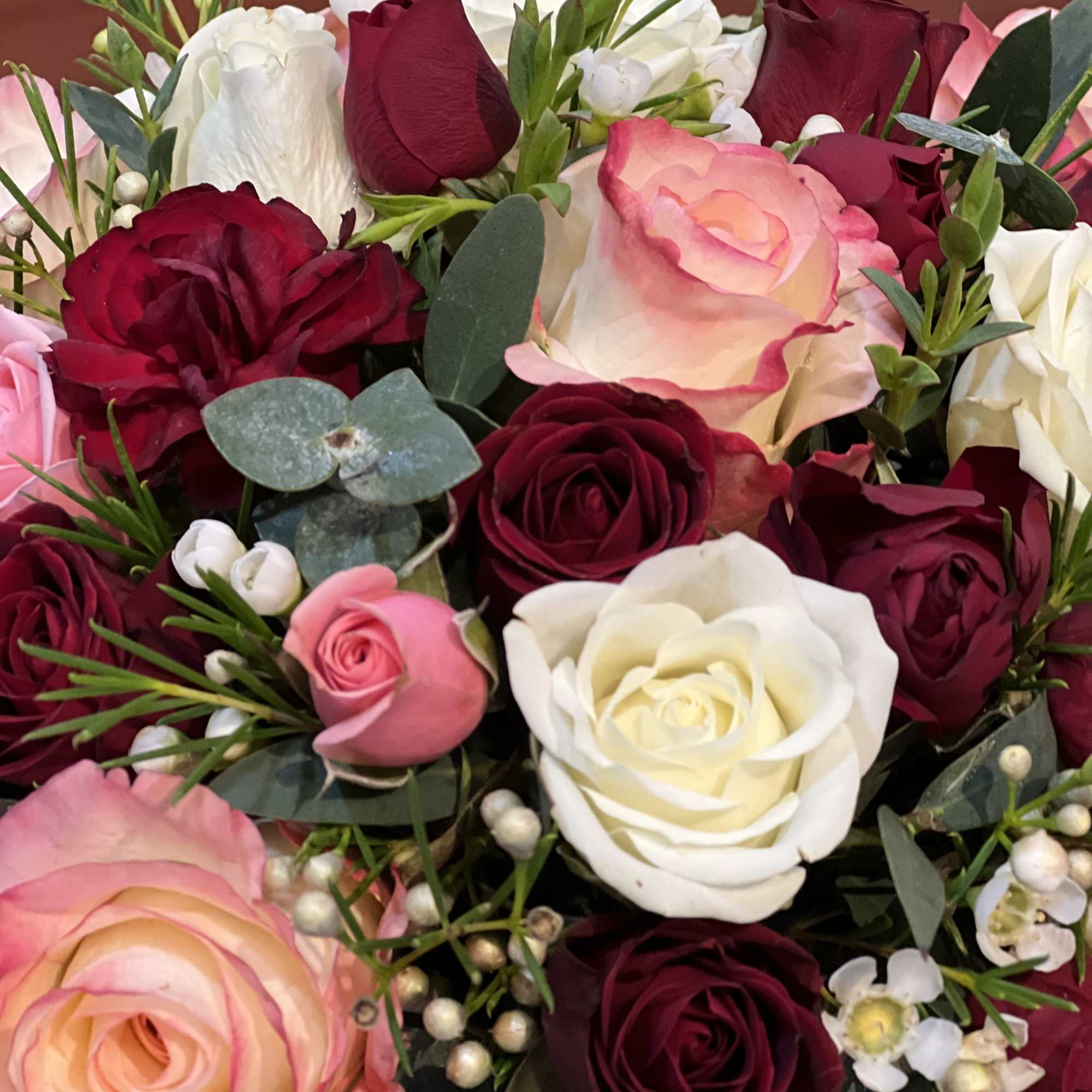 Bouquet of red, pink, and white roses with eucalyptus accents