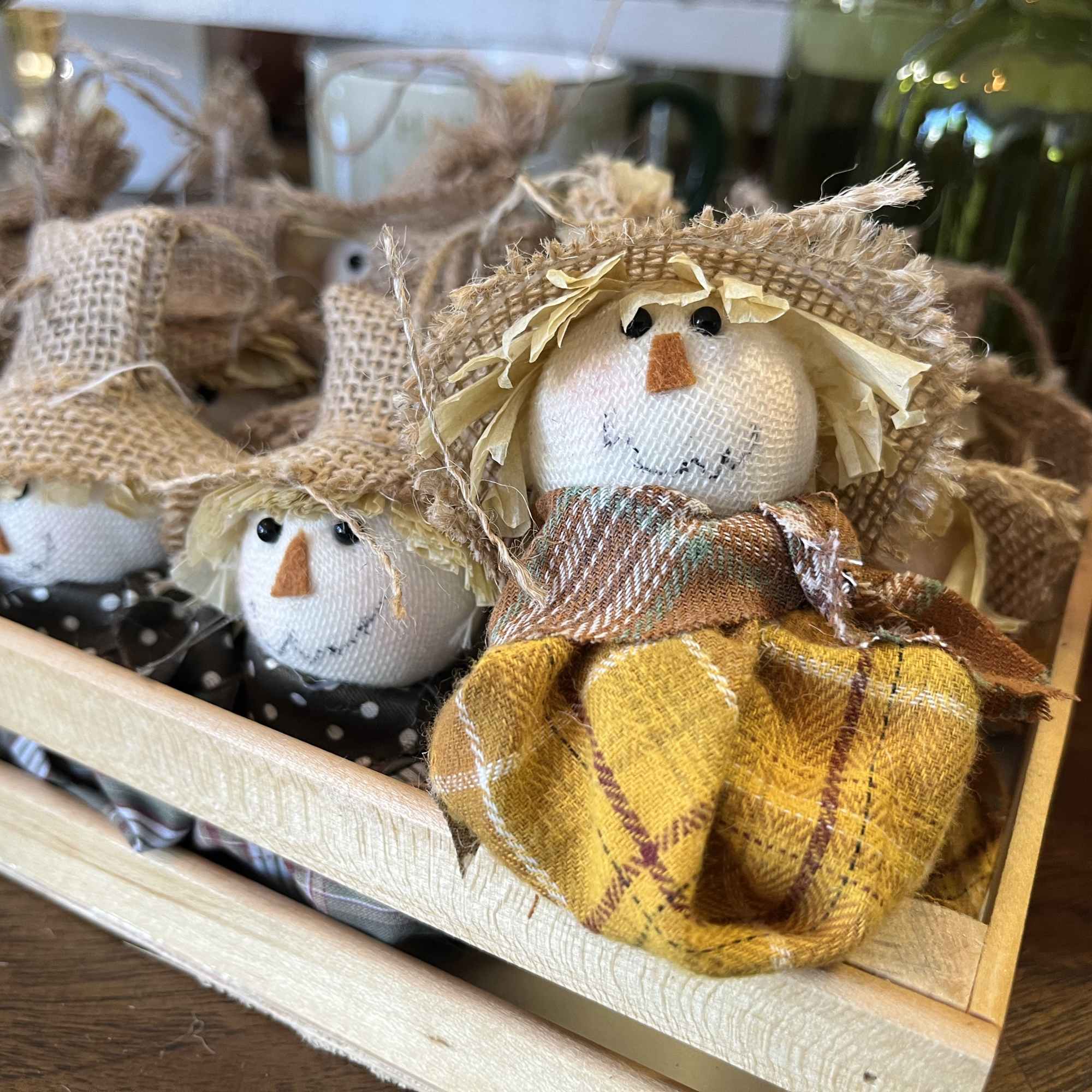 Tray of small fabric scarecrow dolls with straw hats