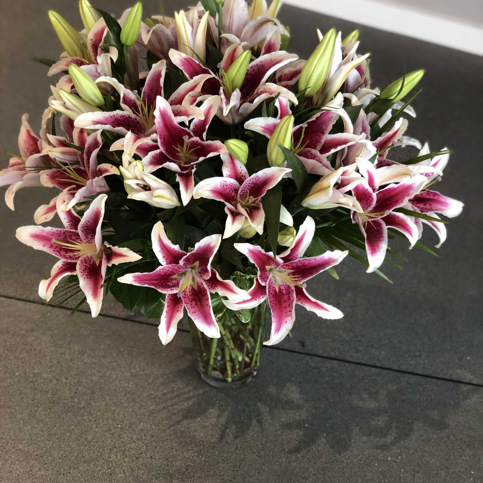 Bouquet of pink-and-white lilies in a clear glass vase, photo 12 of 16