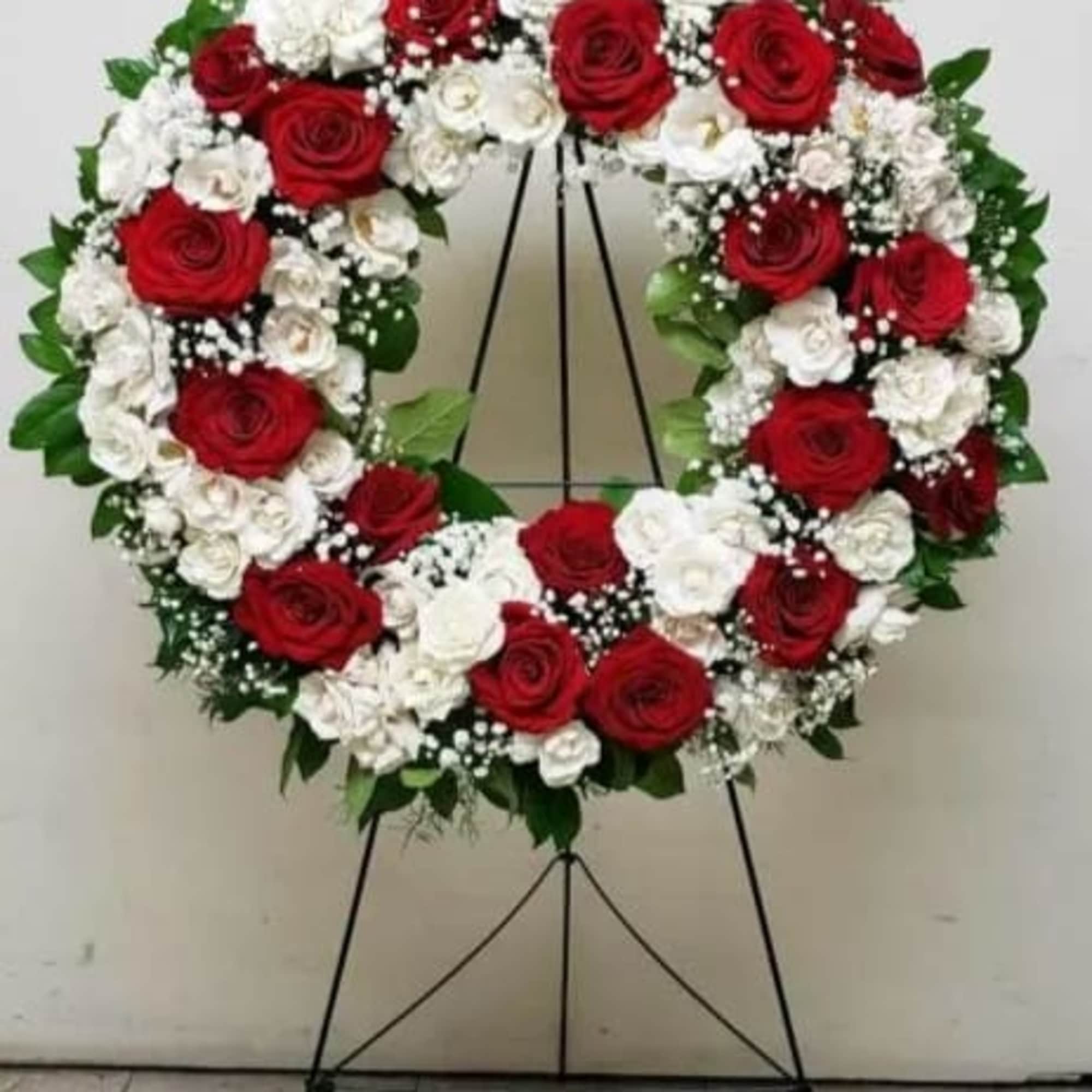 Large red and white rose wreath on a metal easel stand