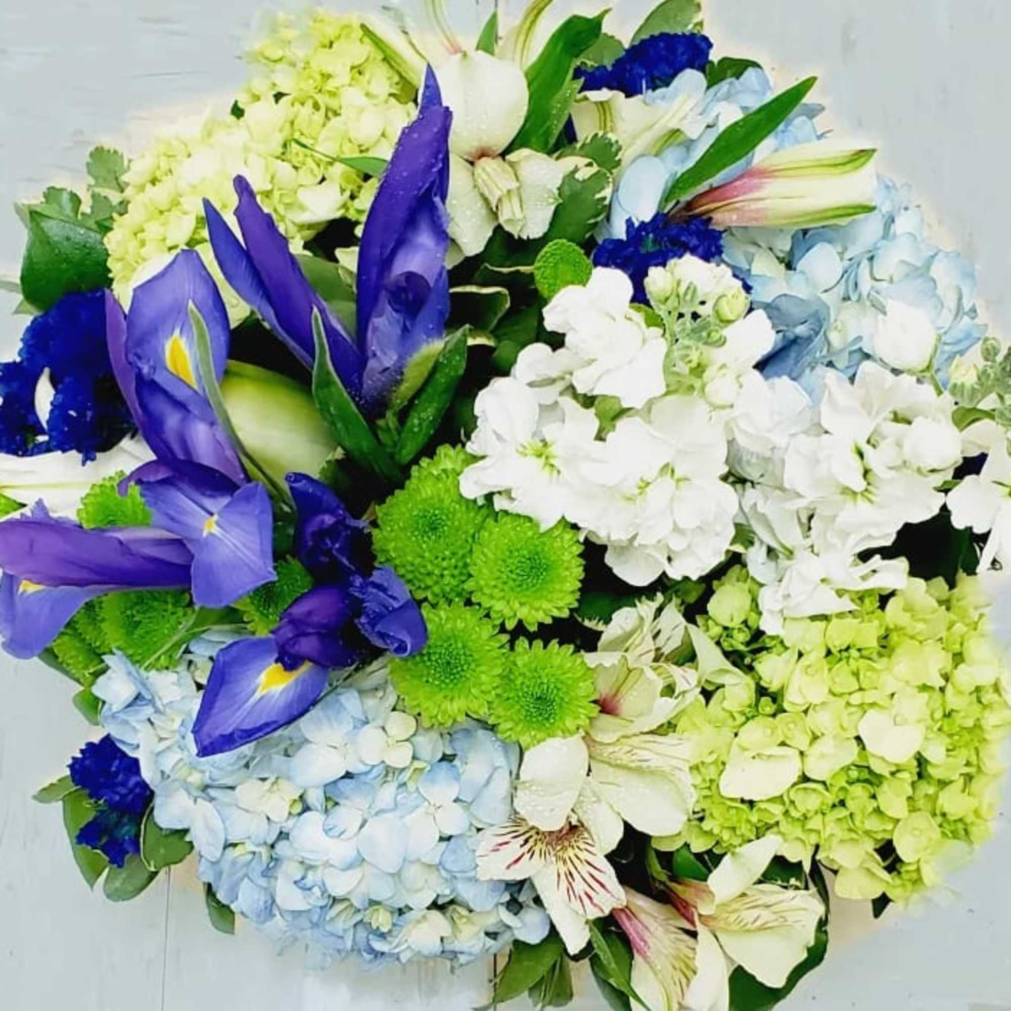 Bouquet of blue irises, hydrangeas, and white flowers
