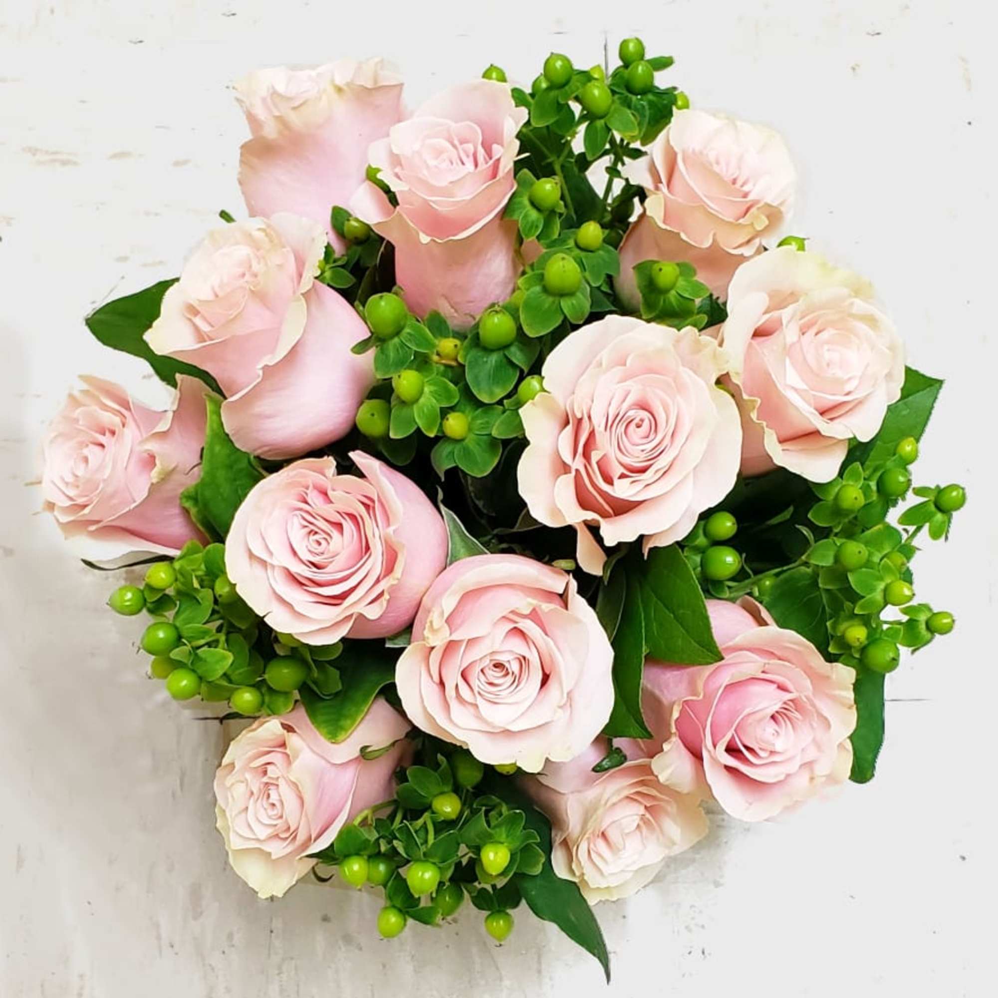 Bouquet of pale pink roses with bright green berries