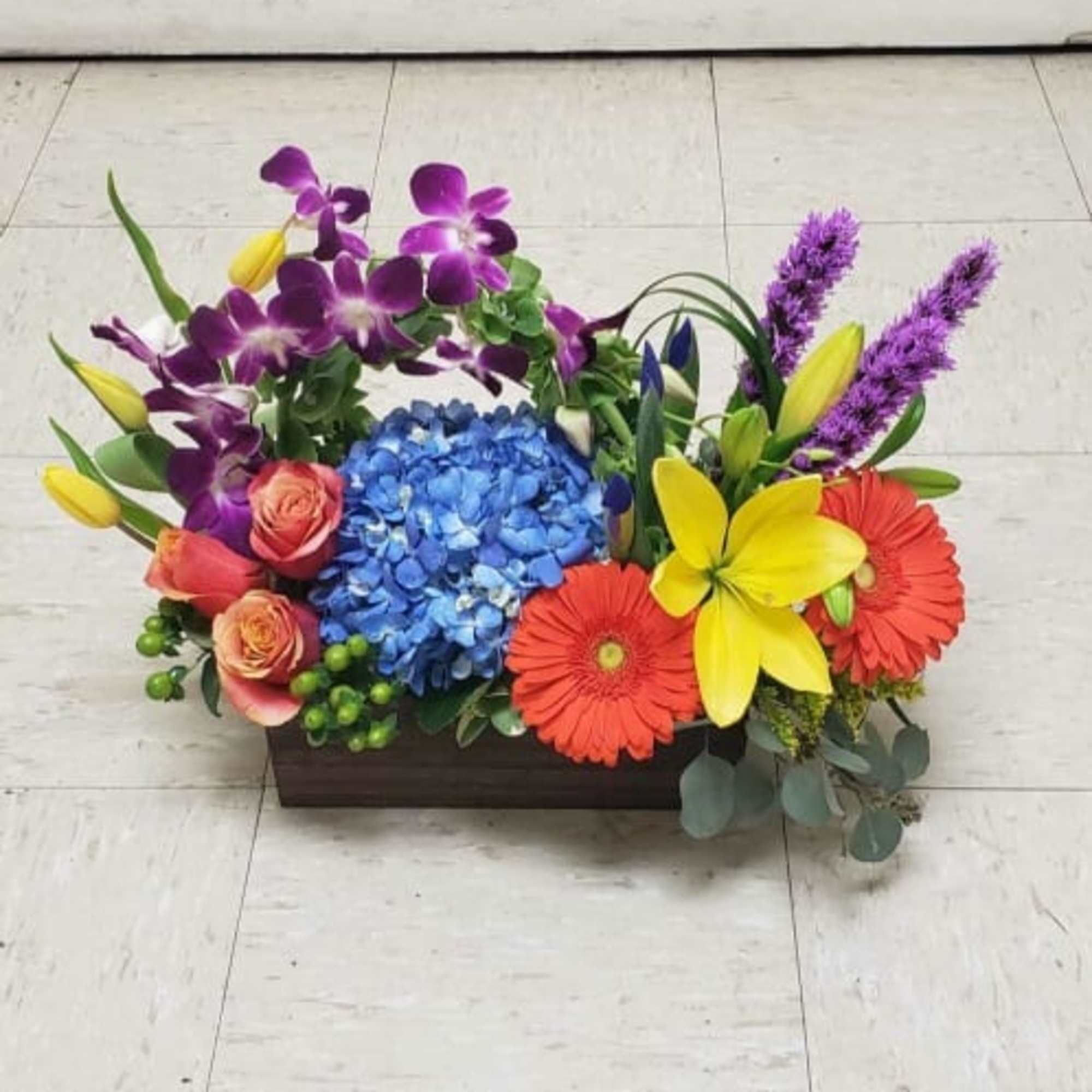 Colorful flower arrangement in a rectangular wooden container