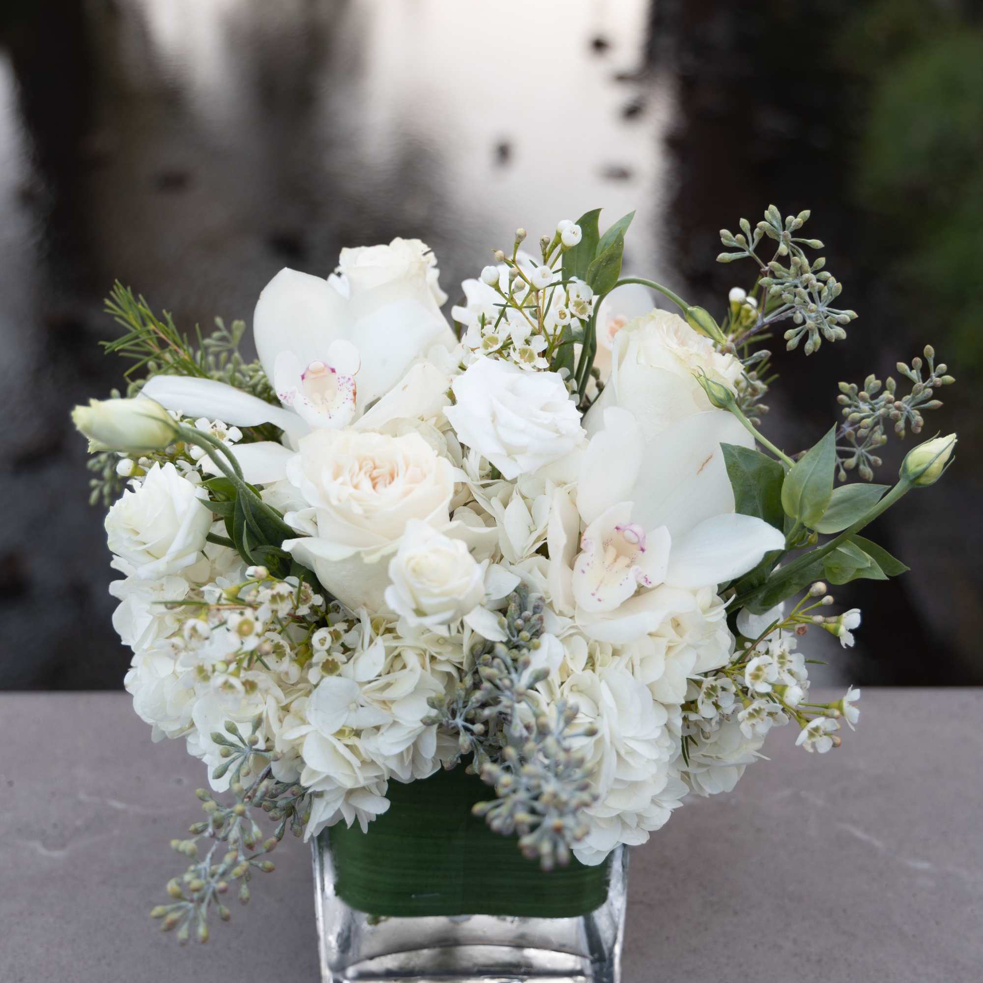 White floral arrangement in a clear square vase, photo 2 of 2