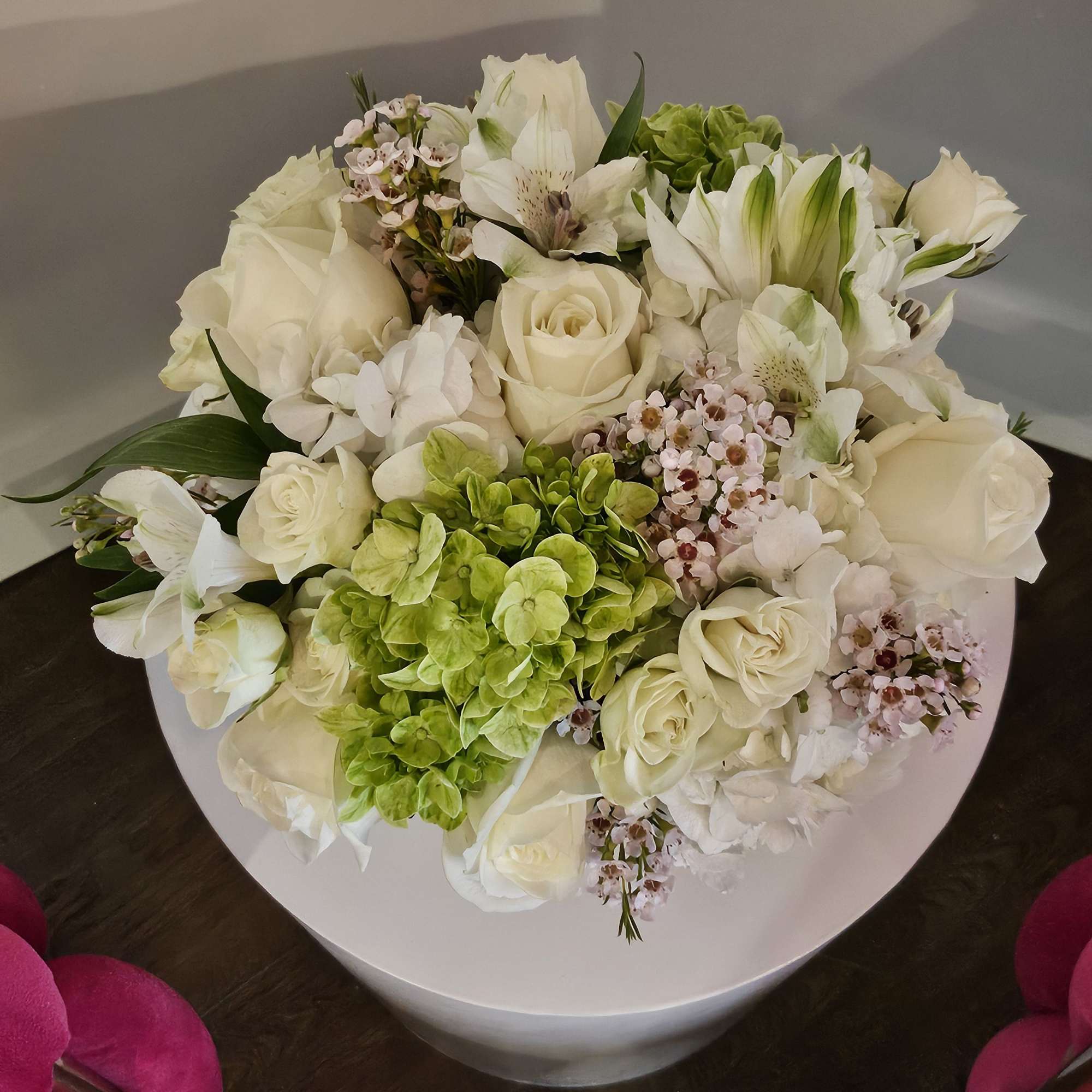 White rose and lily bouquet with green hydrangea in a round white box