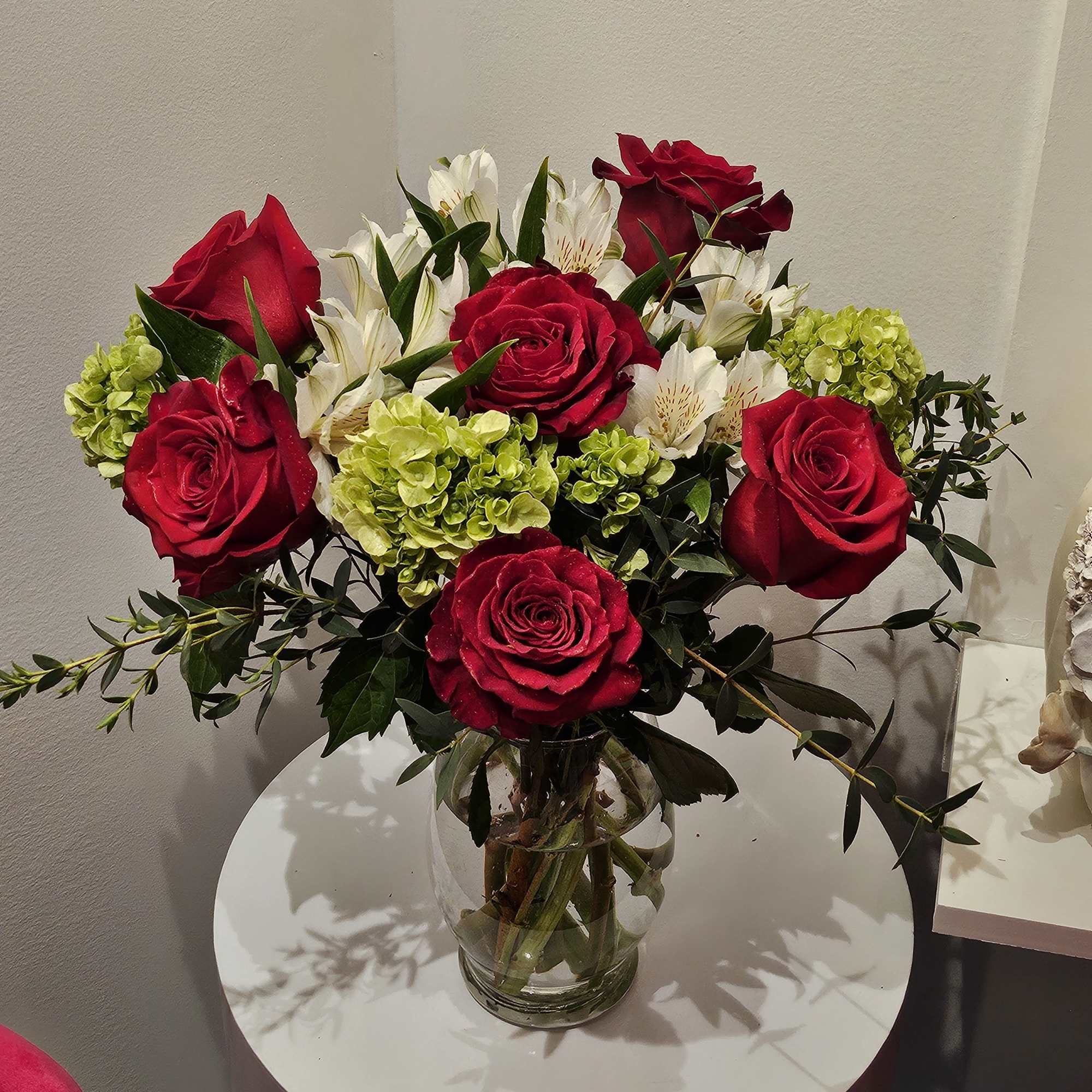Red roses and white alstroemeria in a clear glass vase
