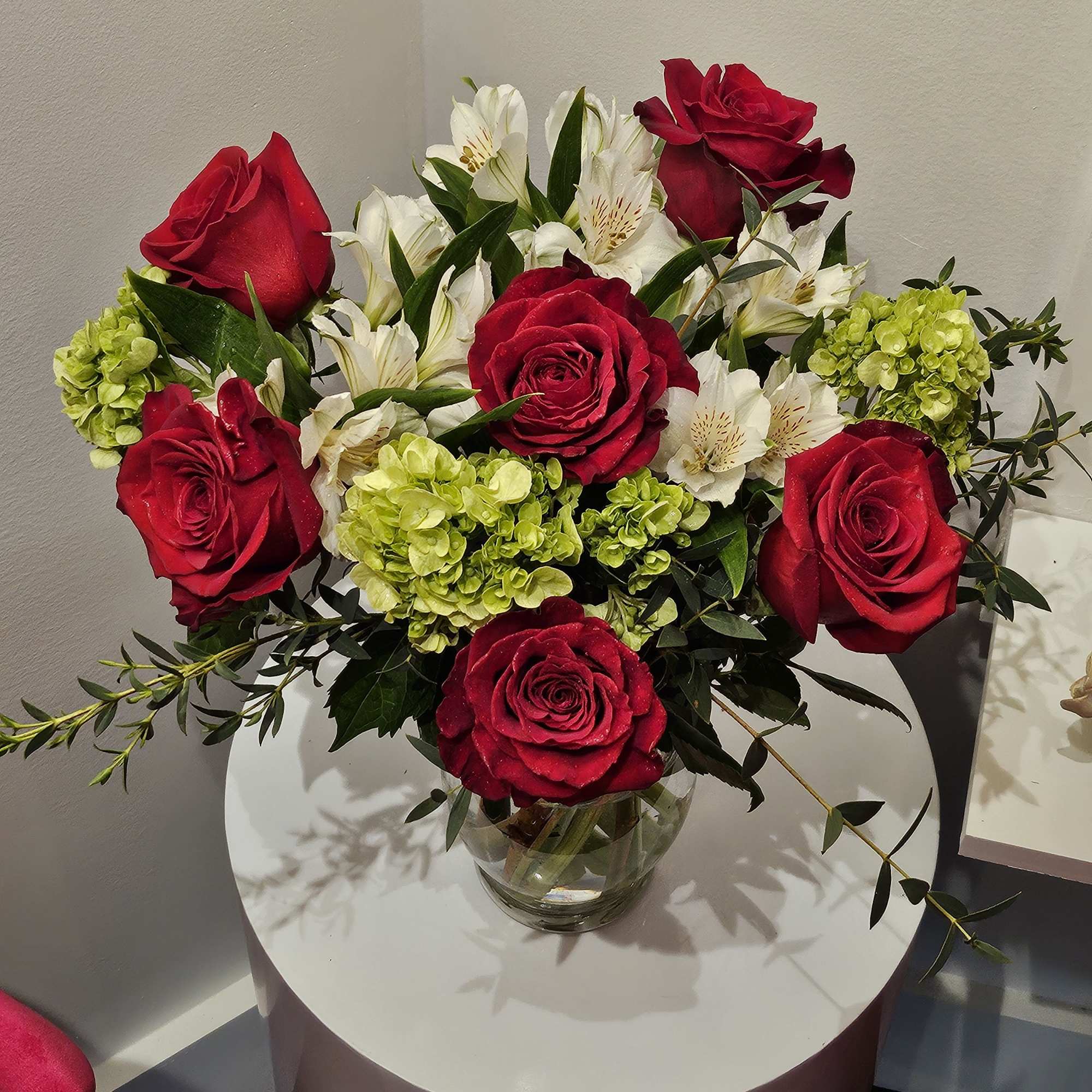 Red roses and white alstroemeria in a clear glass vase, photo 3 of 3
