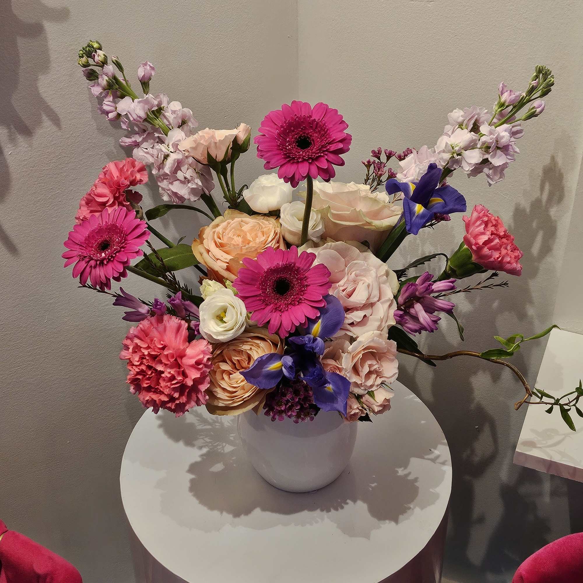 Mixed bouquet in a white vase with pink, peach, and purple flowers