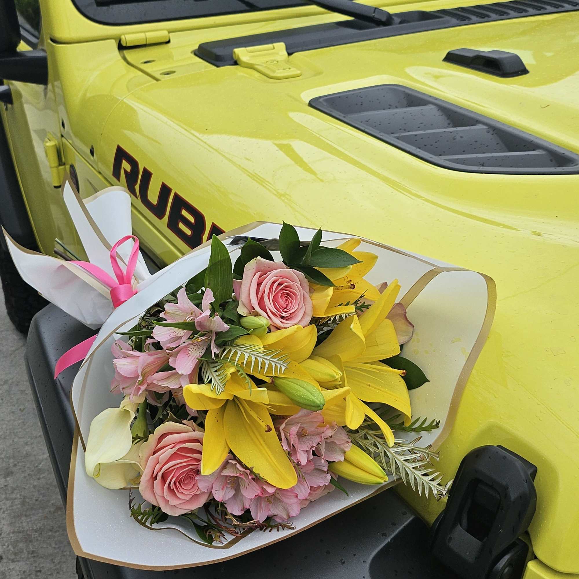 Bouquet of pink roses, yellow lilies, and pale pink flowers wrapped in white paper, photo 2 of 3