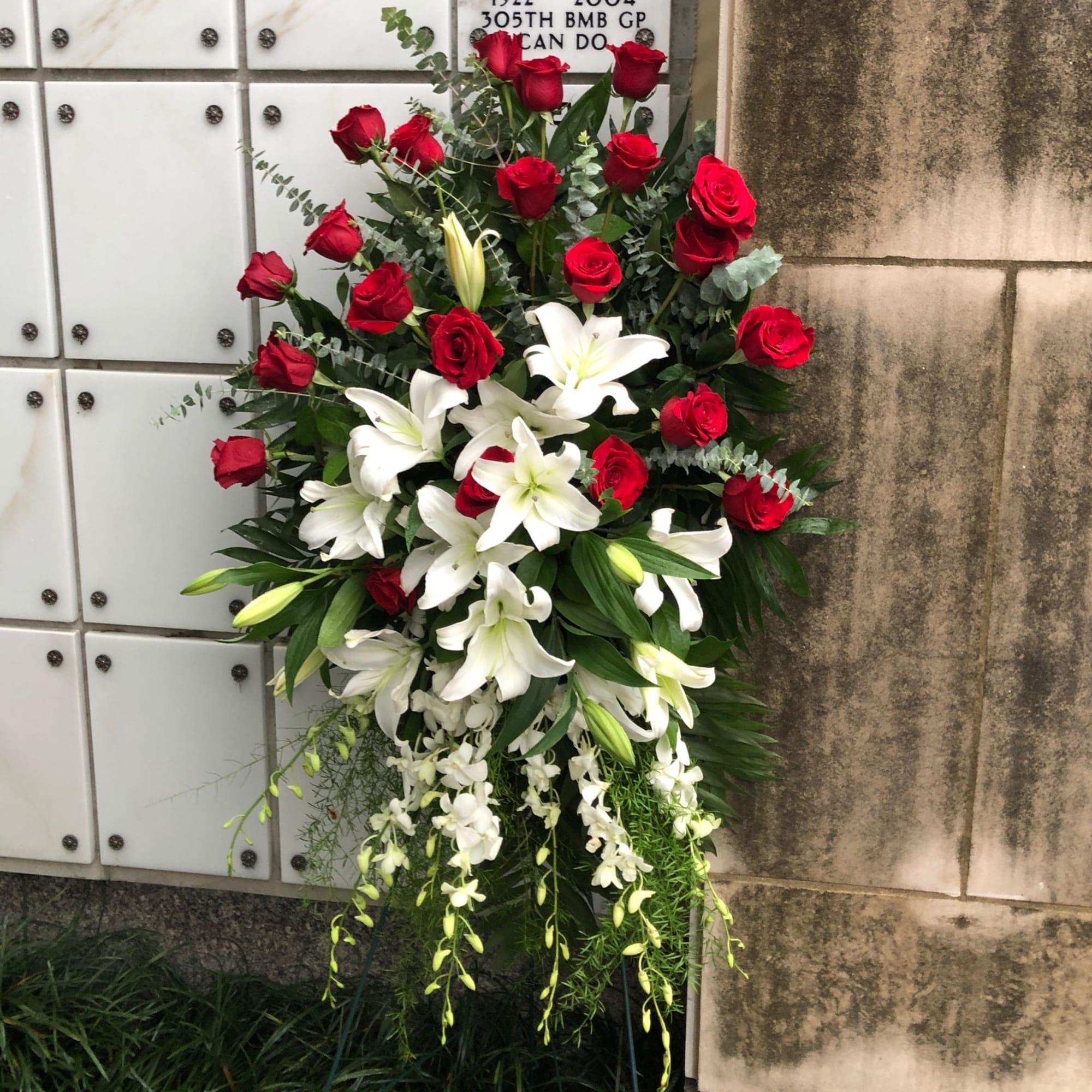 Pure white lilies and dendrobium orchids mingle with red roses, white asiatic