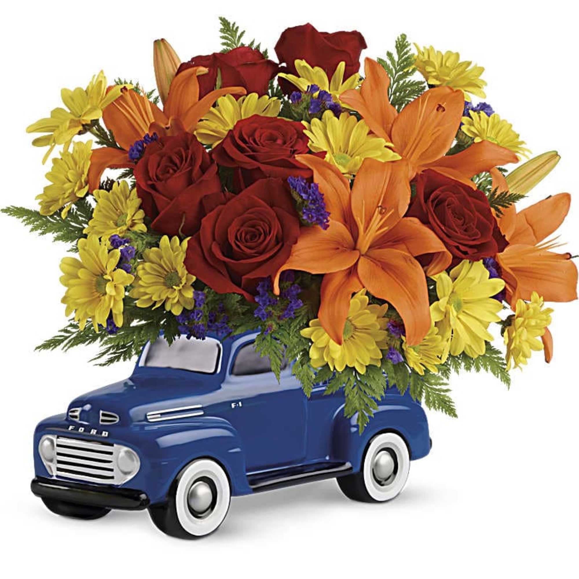 Bouquet of red roses, orange lilies, and yellow daisies in a blue truck container