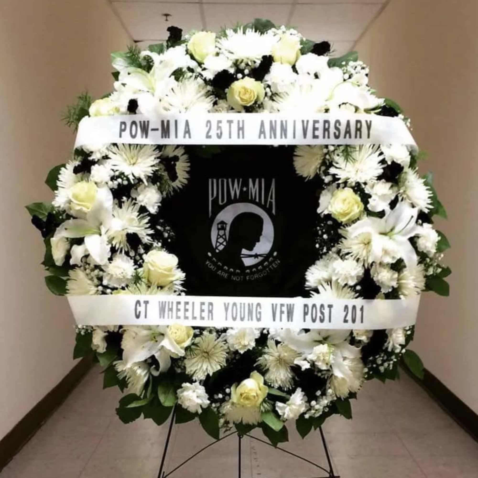 White funeral wreath with ribbons and a POW-MIA tribute center