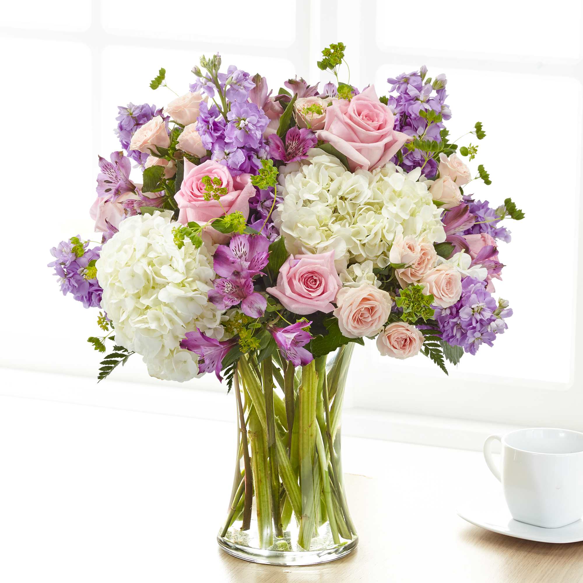 Pink roses and white hydrangeas in a clear glass vase