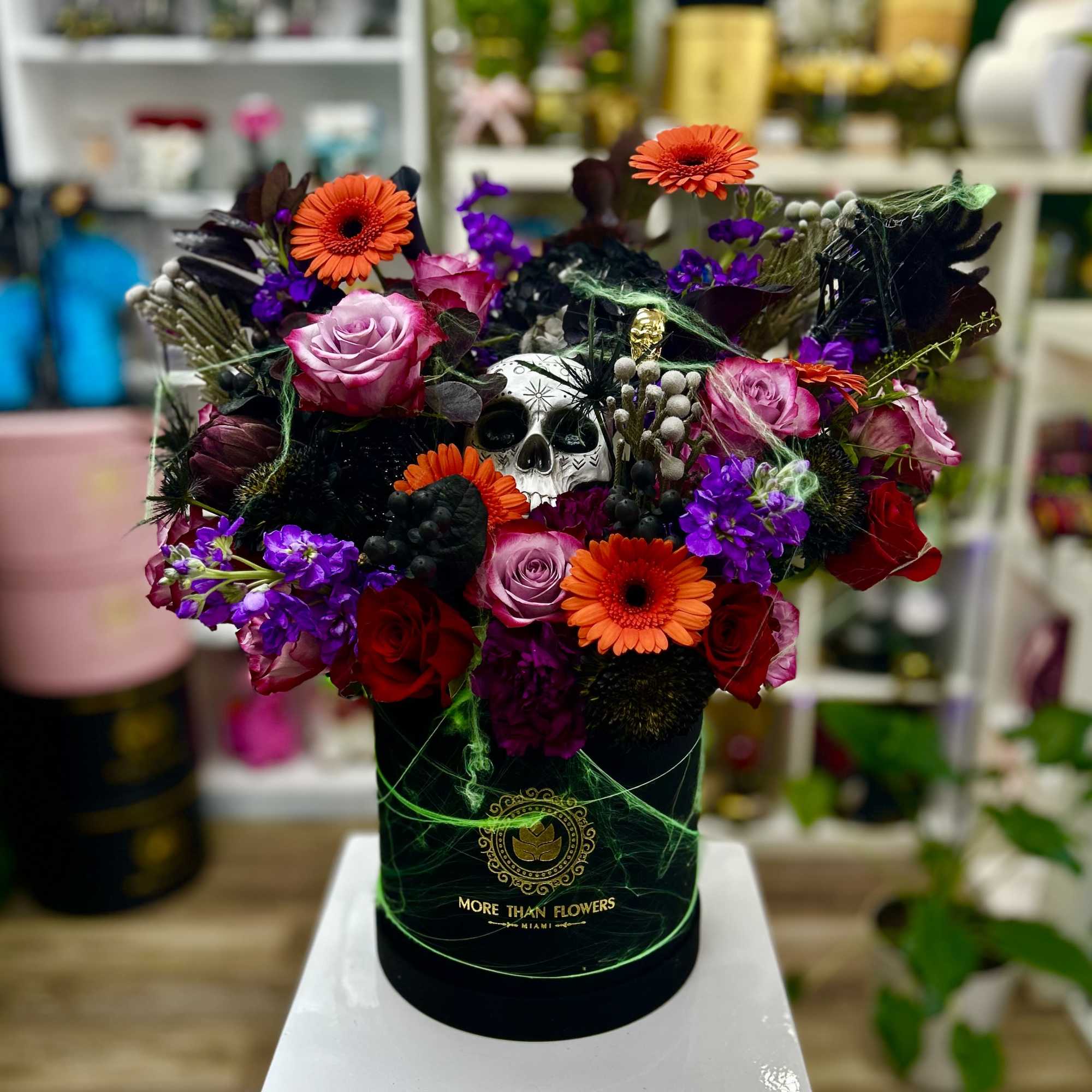 Halloween flower hatbox with orange gerbera, purple blooms, red roses and decorative skull