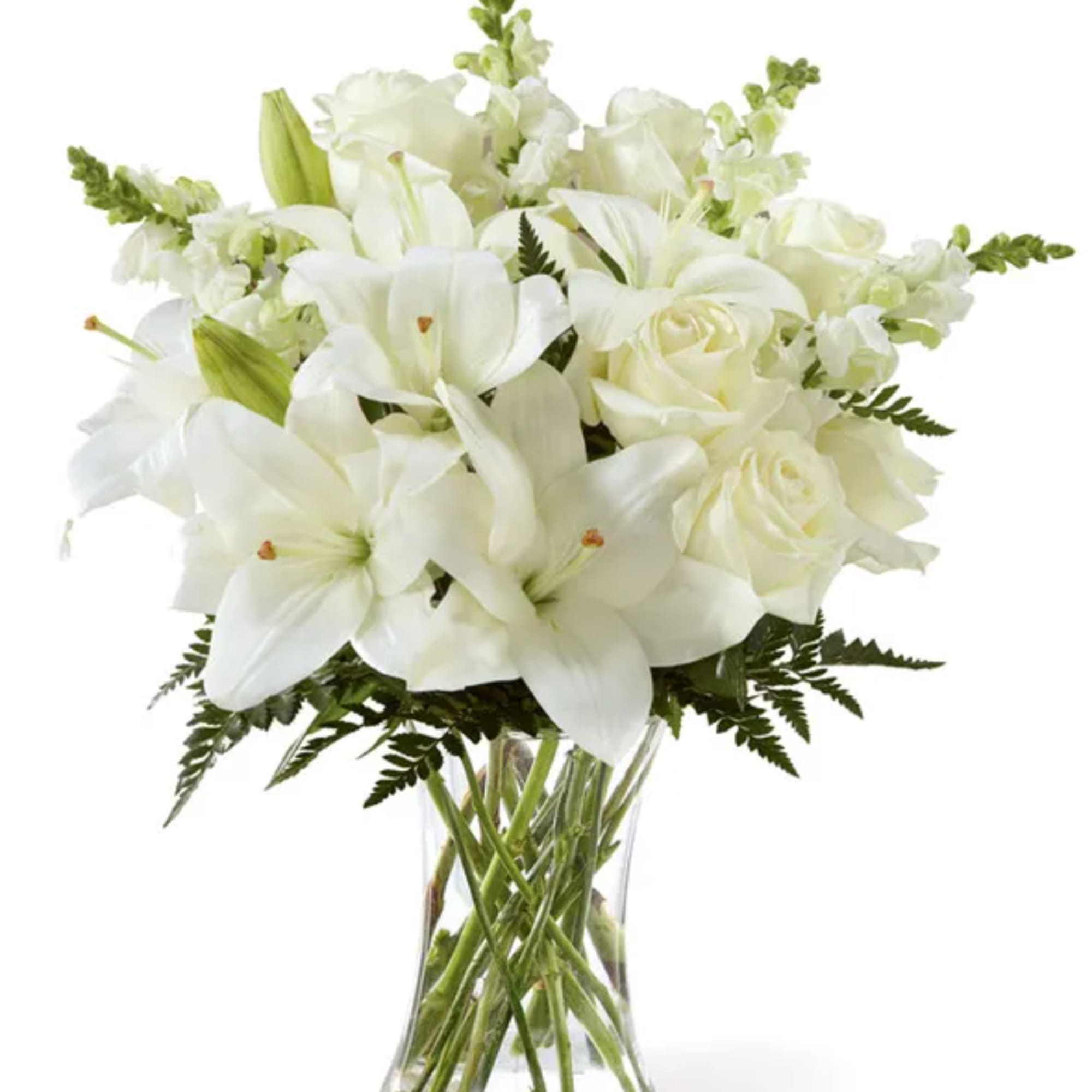 White lilies and roses arranged in a clear glass vase