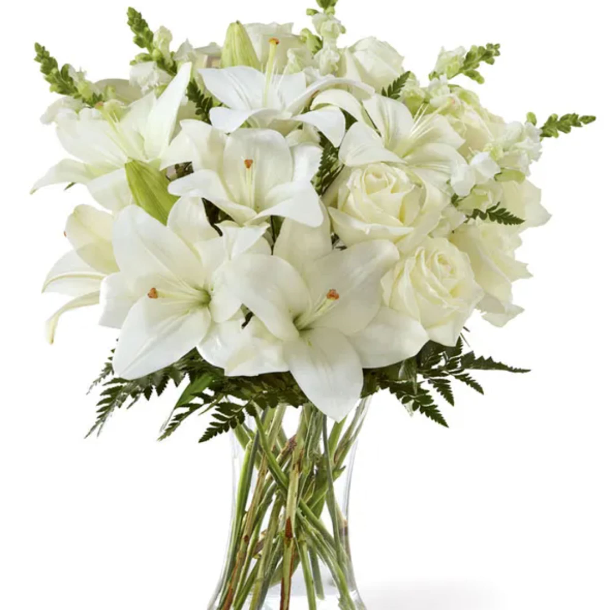 White lilies and roses arranged in a clear glass vase