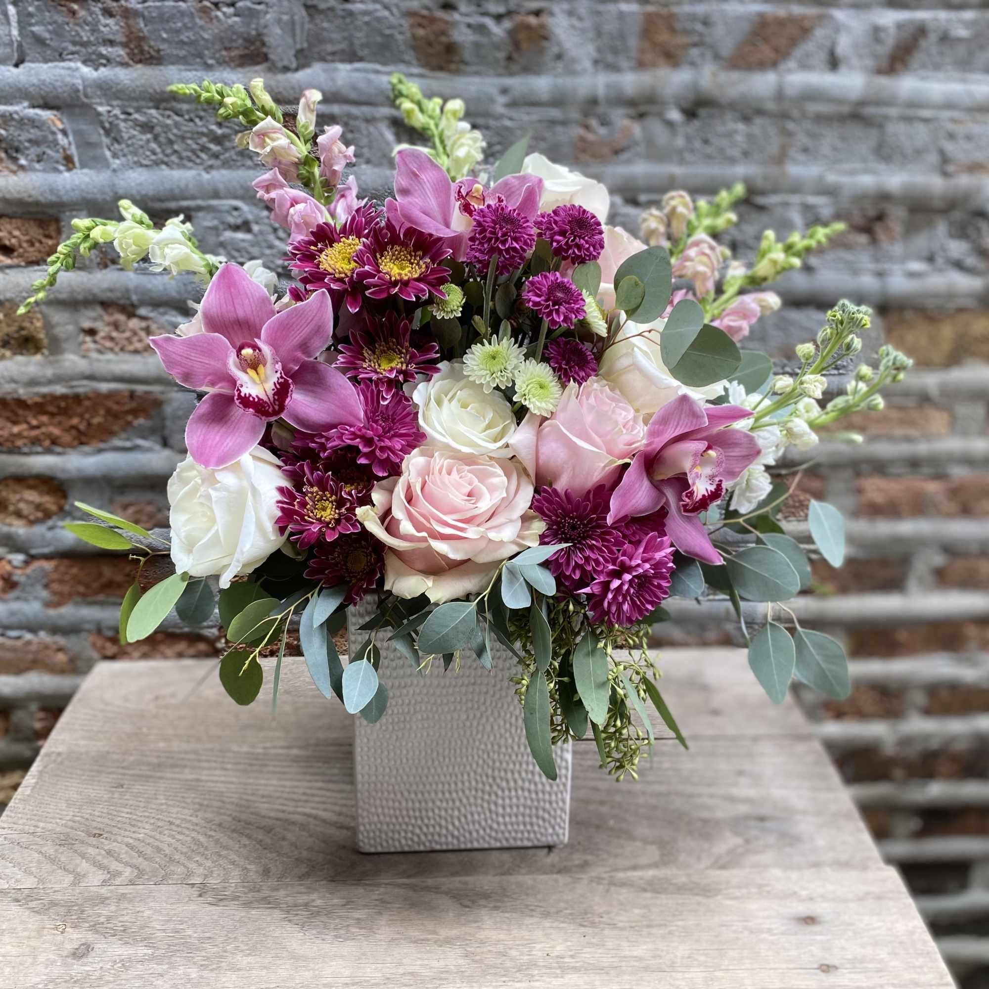 Pink and white floral arrangement in a square vase