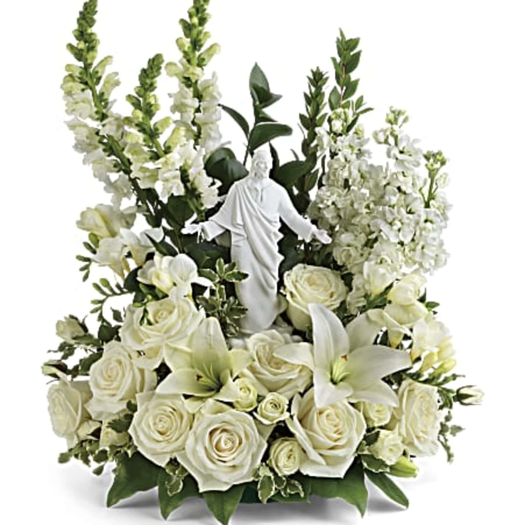 White floral arrangement with a religious statue centerpiece