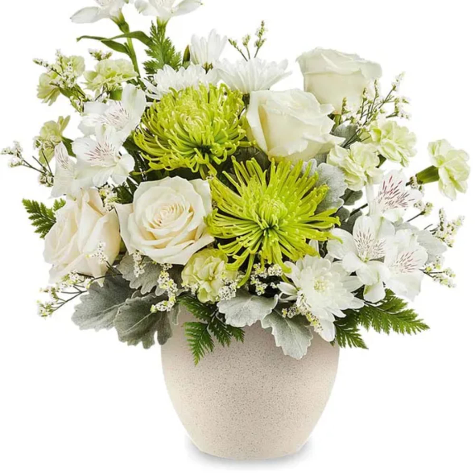 White and green floral arrangement in a beige vase