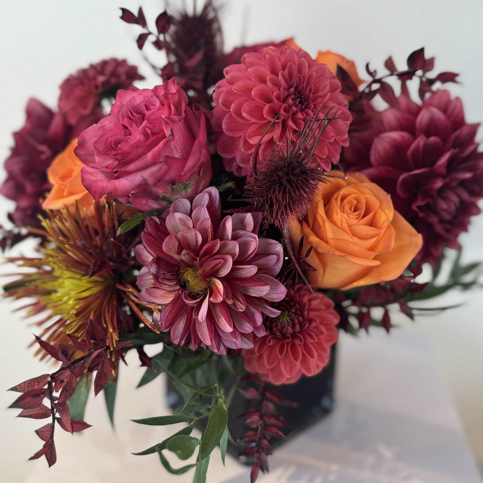 Bouquet of pink and orange flowers in a dark vase