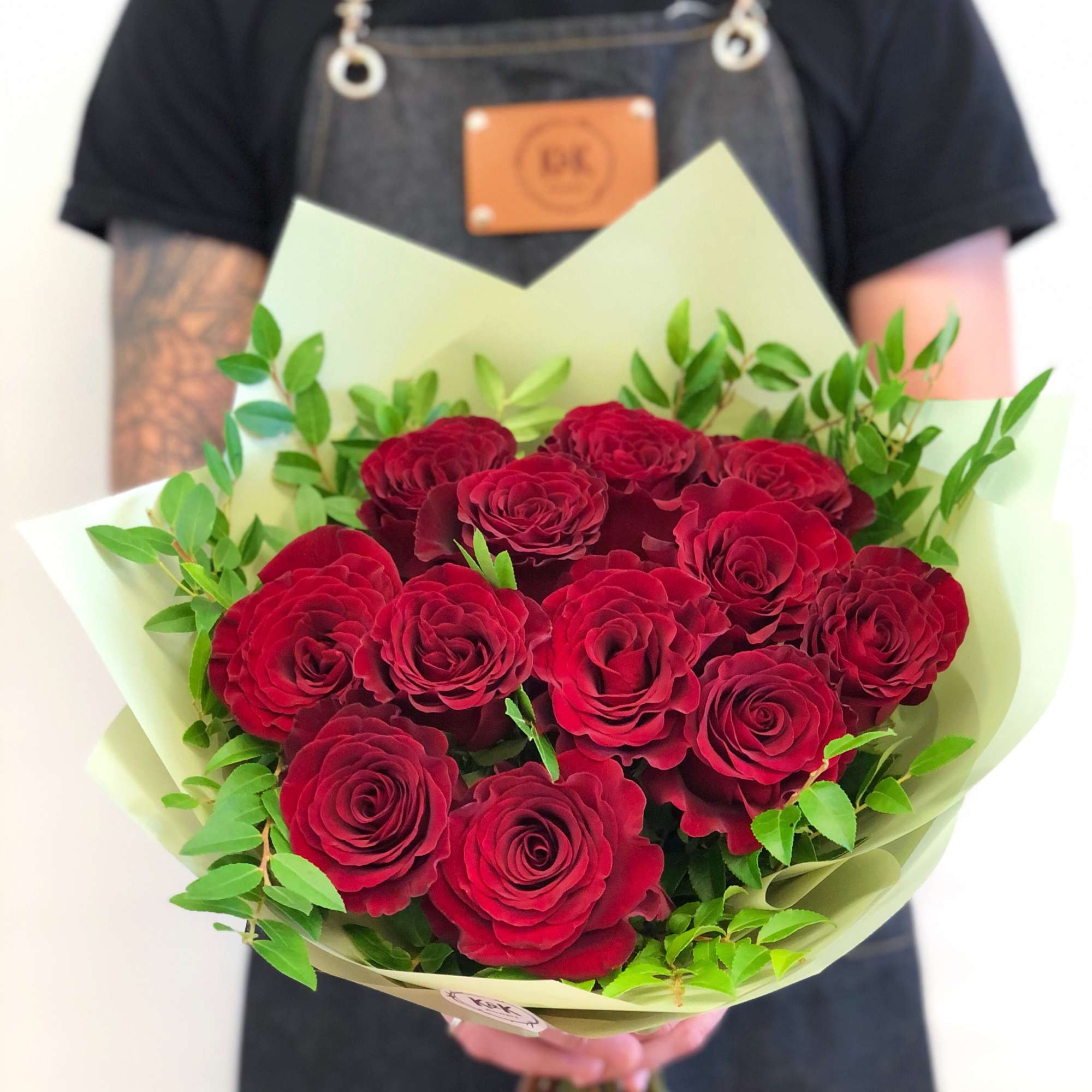 Bouquet of red roses wrapped in pale green paper