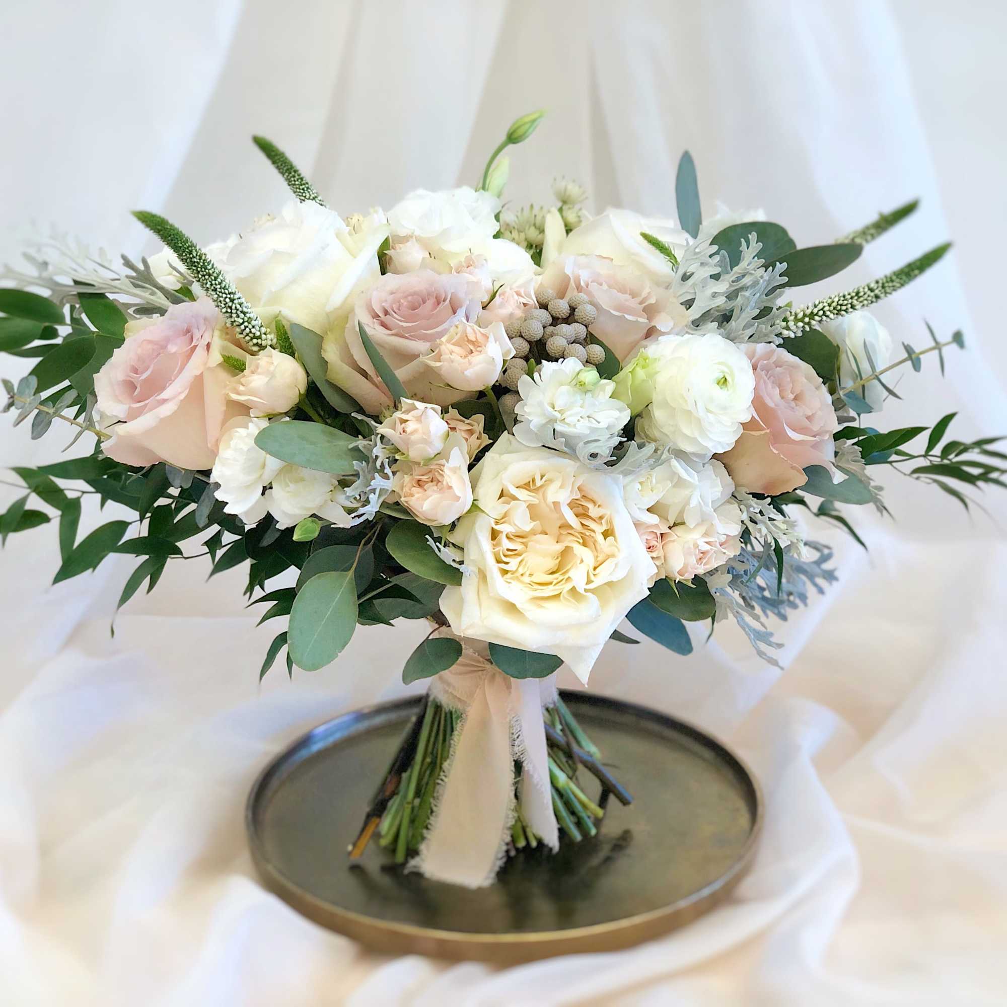 Blush and white rose bouquet with greenery on a ribbon wrap