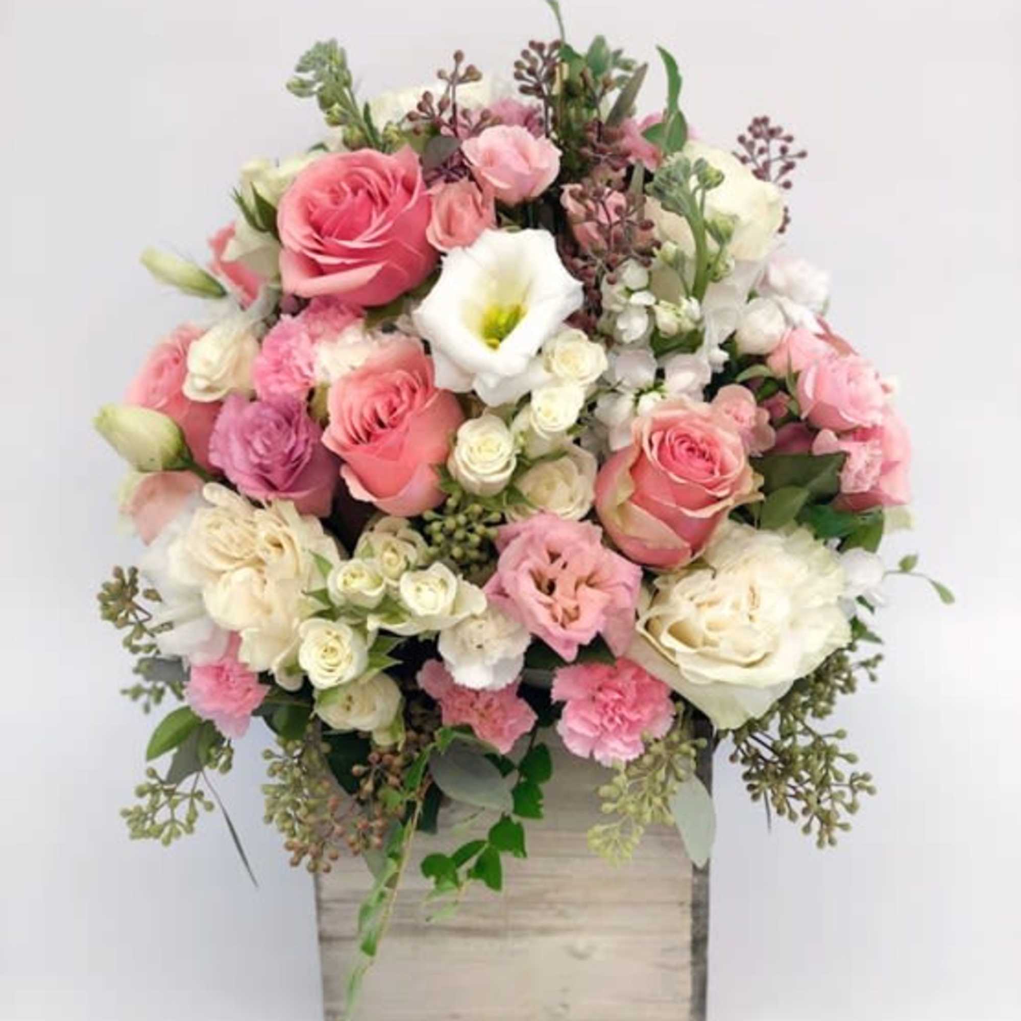 Pink and white rose arrangement in a wooden box