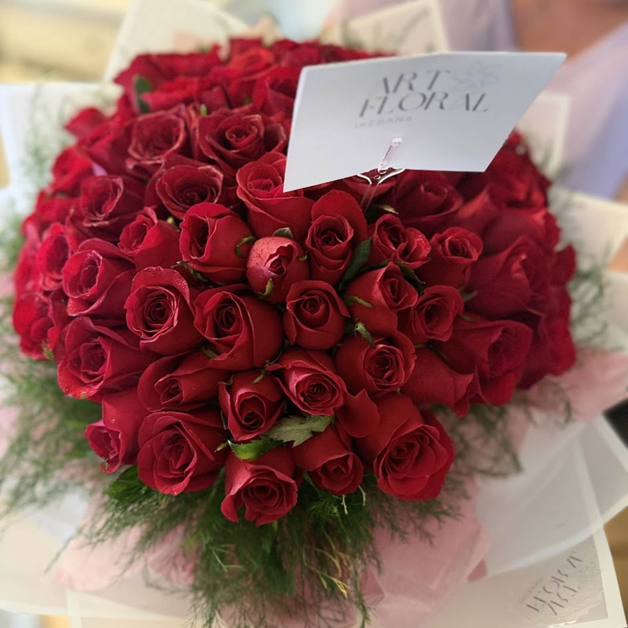 Bouquet of red roses with a white card attached