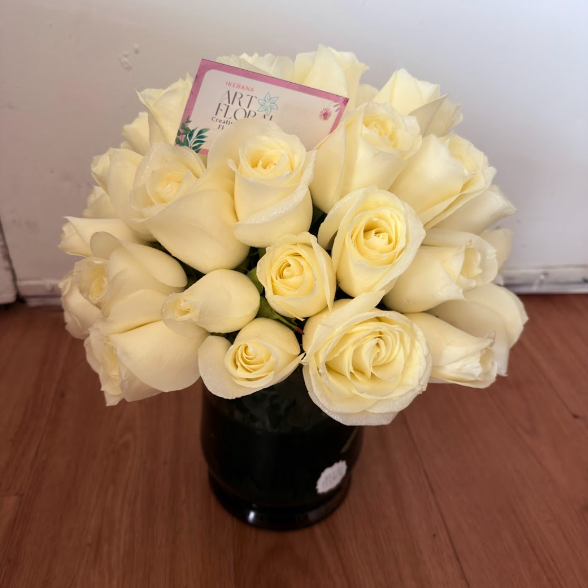 Bouquet of cream roses in a black vase