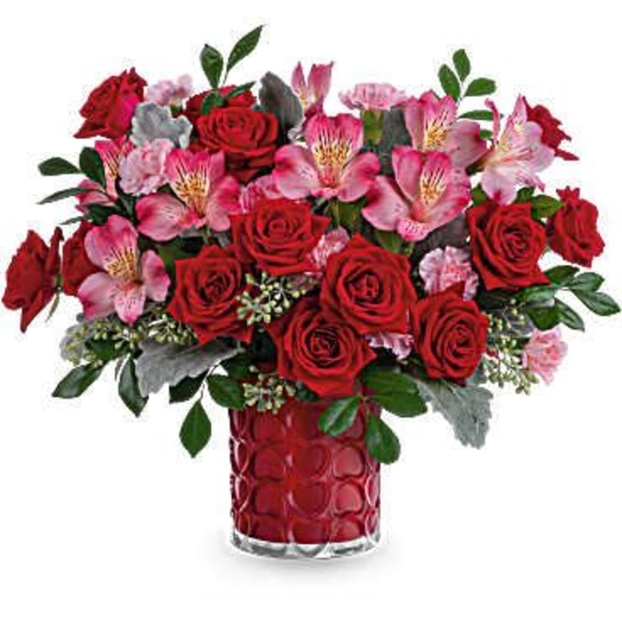 Red roses and pink alstroemeria in a red glass vase