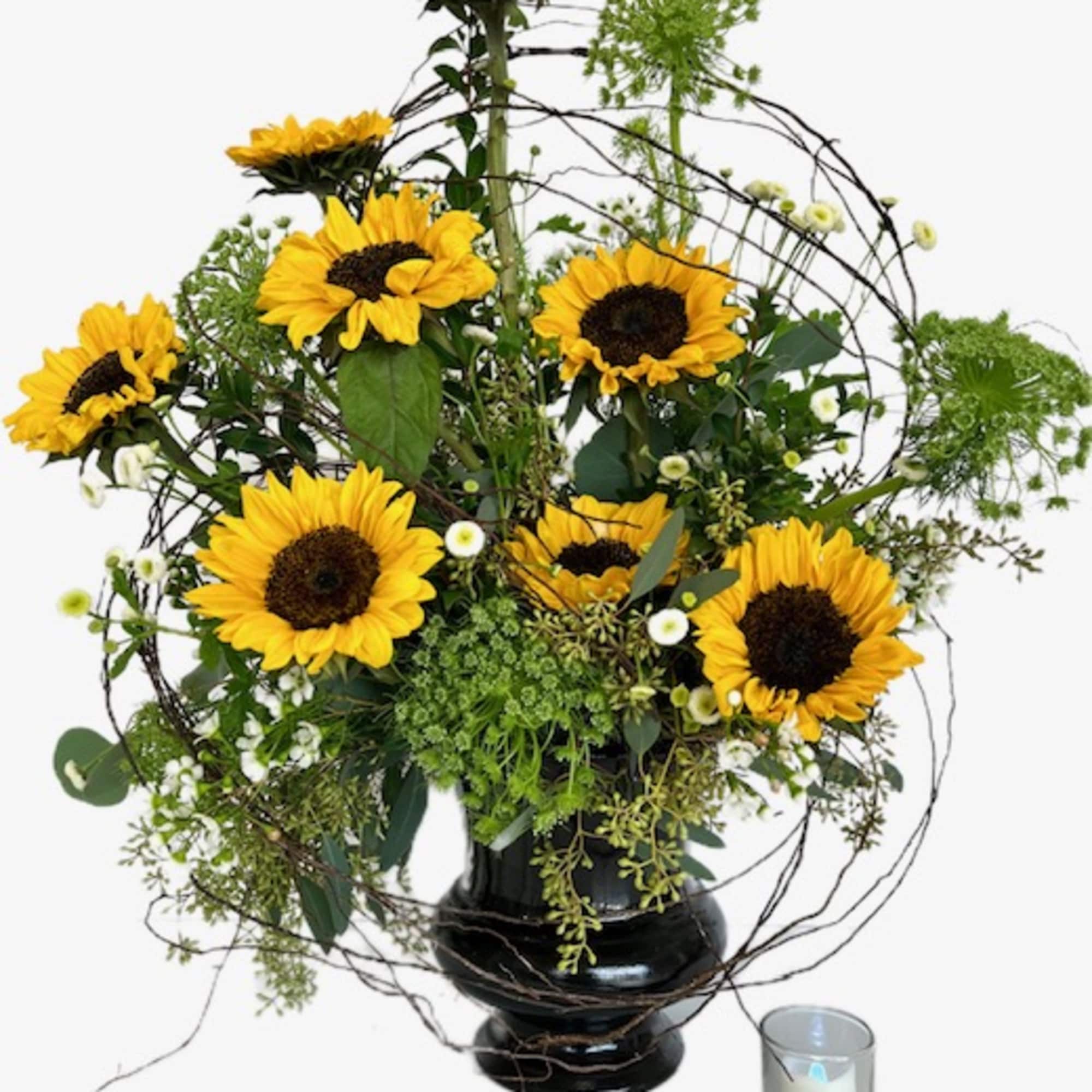Sunflower arrangement in a black vase with a small candle beside it, photo 2 of 2
