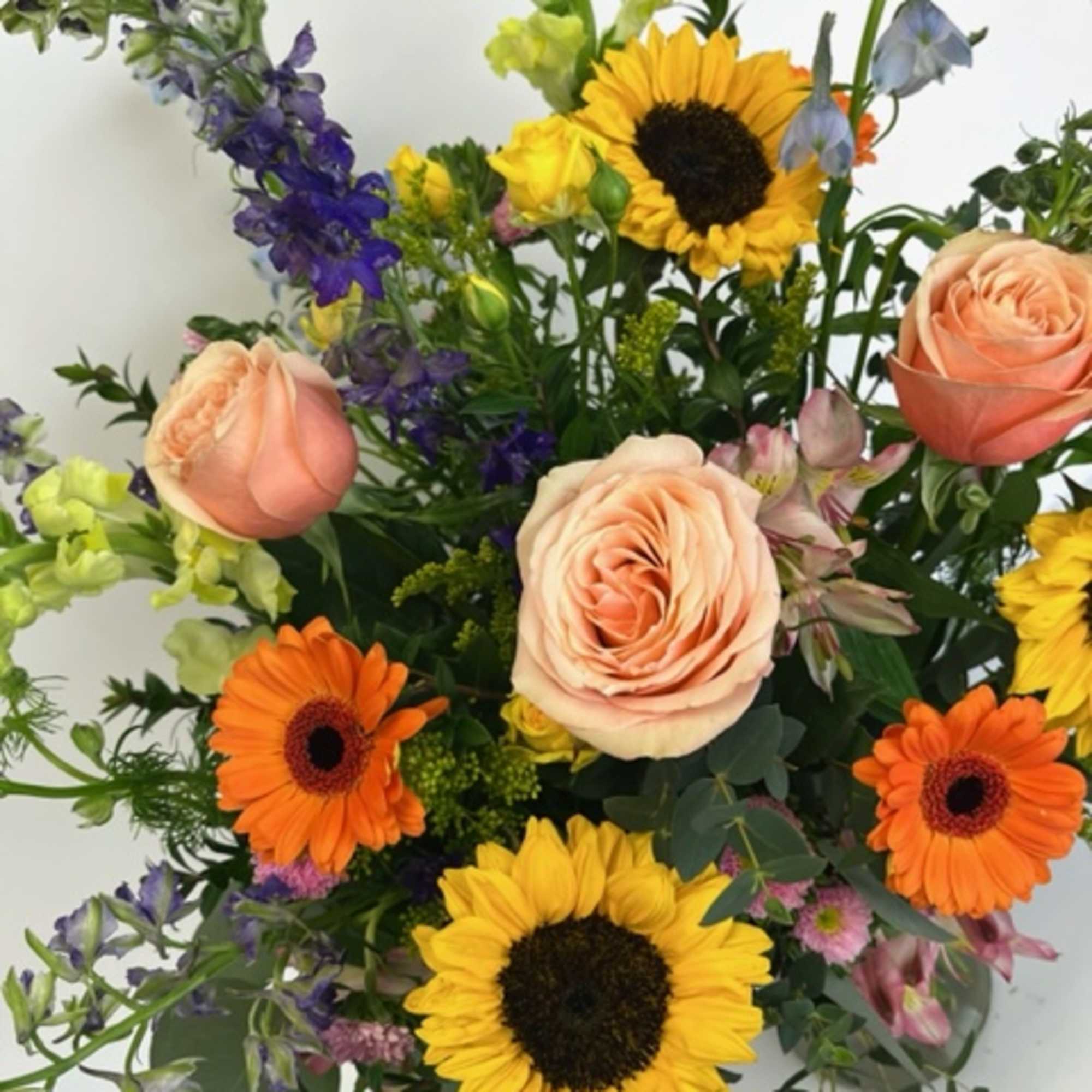 Mixed bouquet with sunflowers, peach roses, and orange gerbera daisies