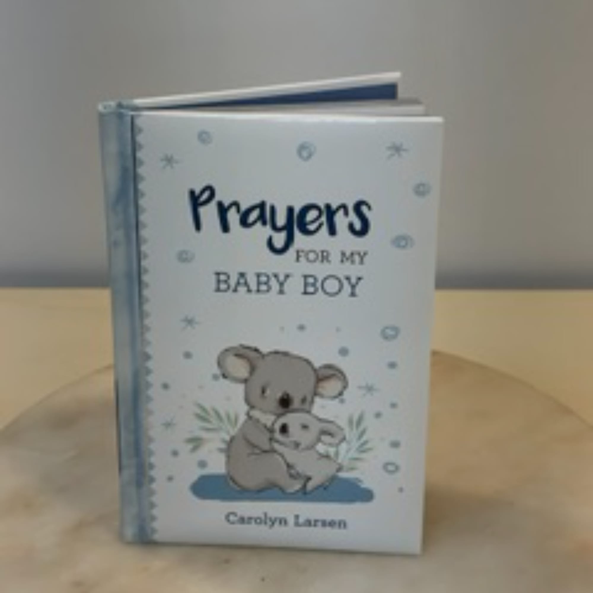 A baby boy prayer book with a koala illustration on the cover