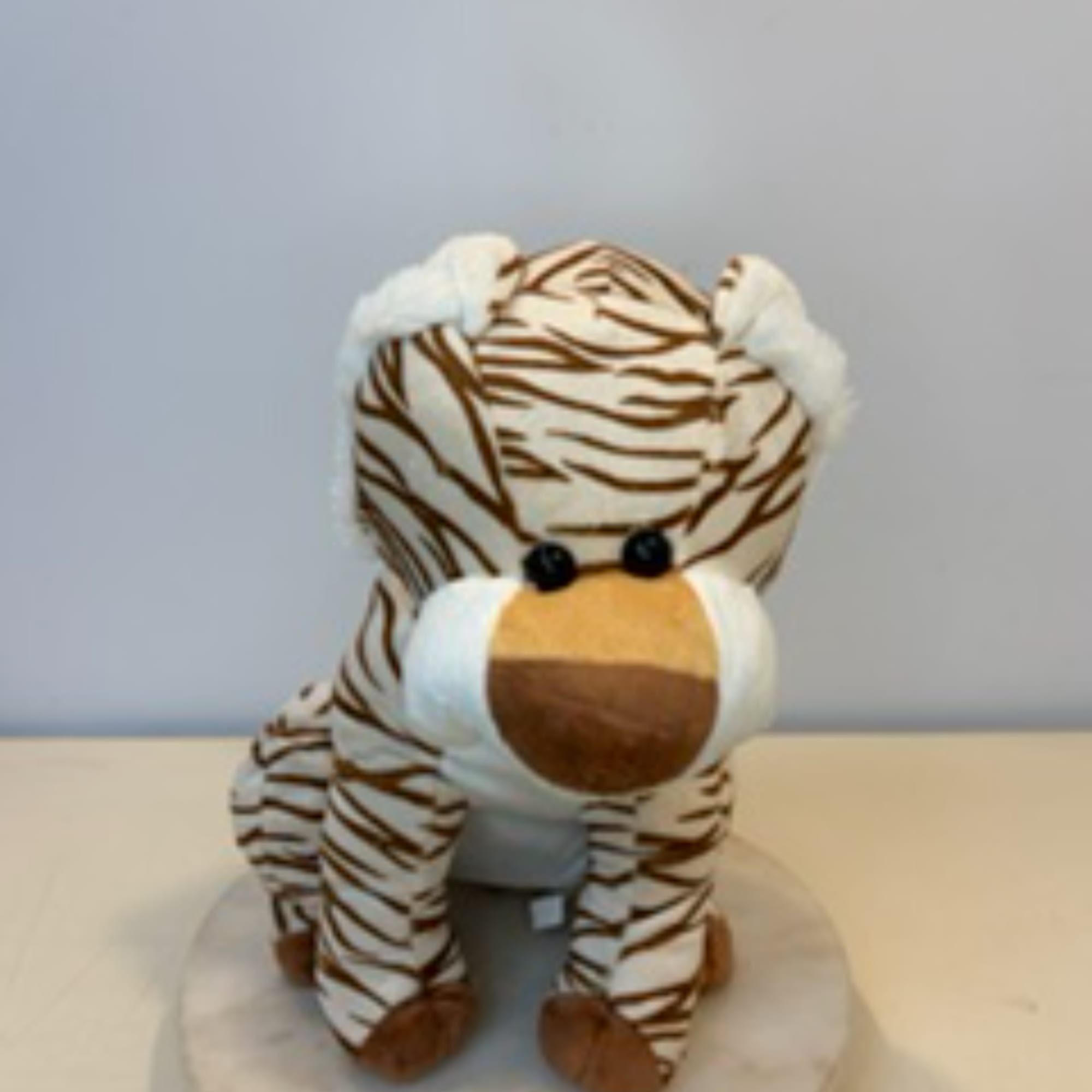 Plush zebra toy sitting on a round base