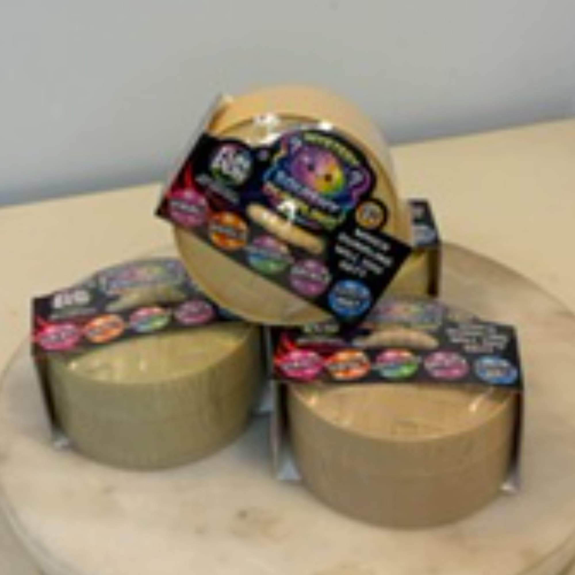Three round gift boxes with colorful labels on a table