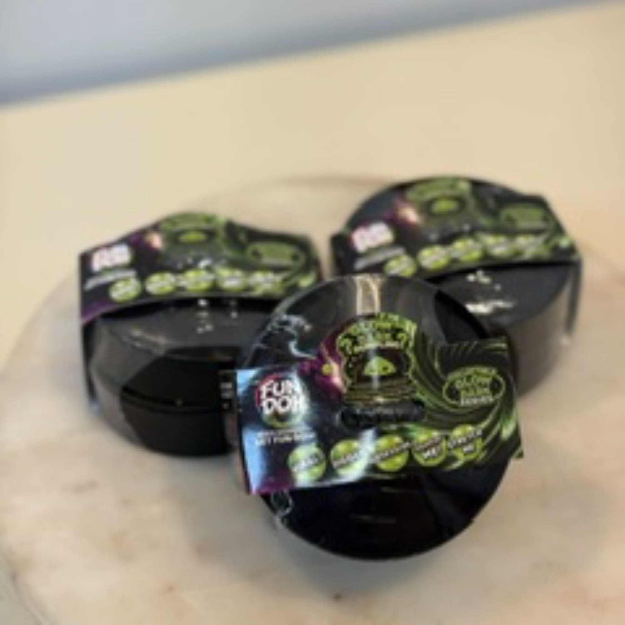 Three black gift containers with Halloween-themed labels