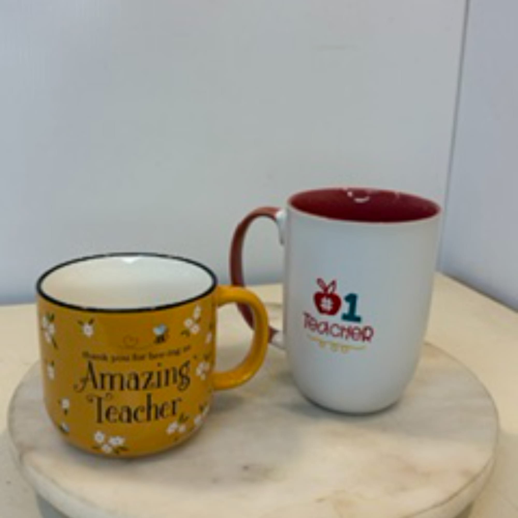Two printed ceramic mugs on a round table