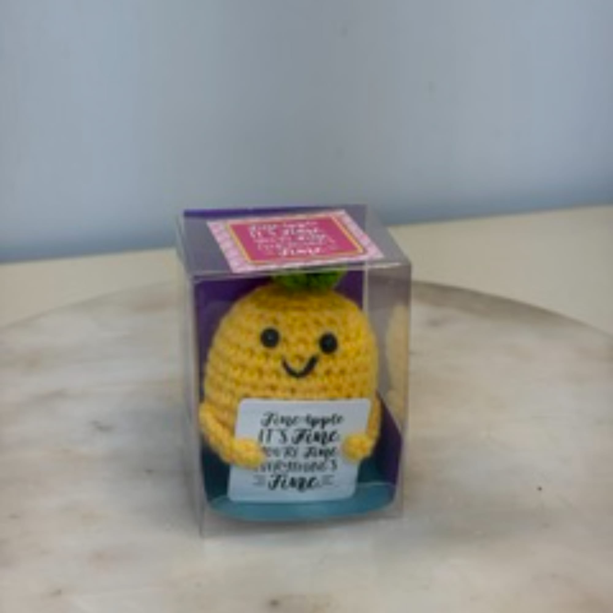 Crocheted pineapple plush in a clear display box
