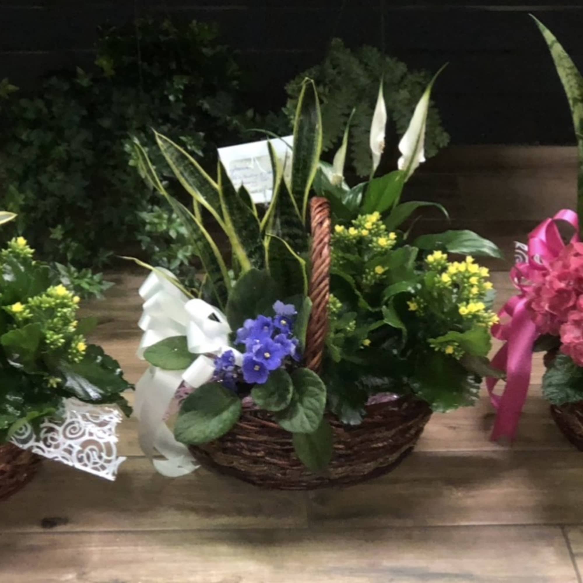Basket arrangements with mixed flowers and ribbon accents