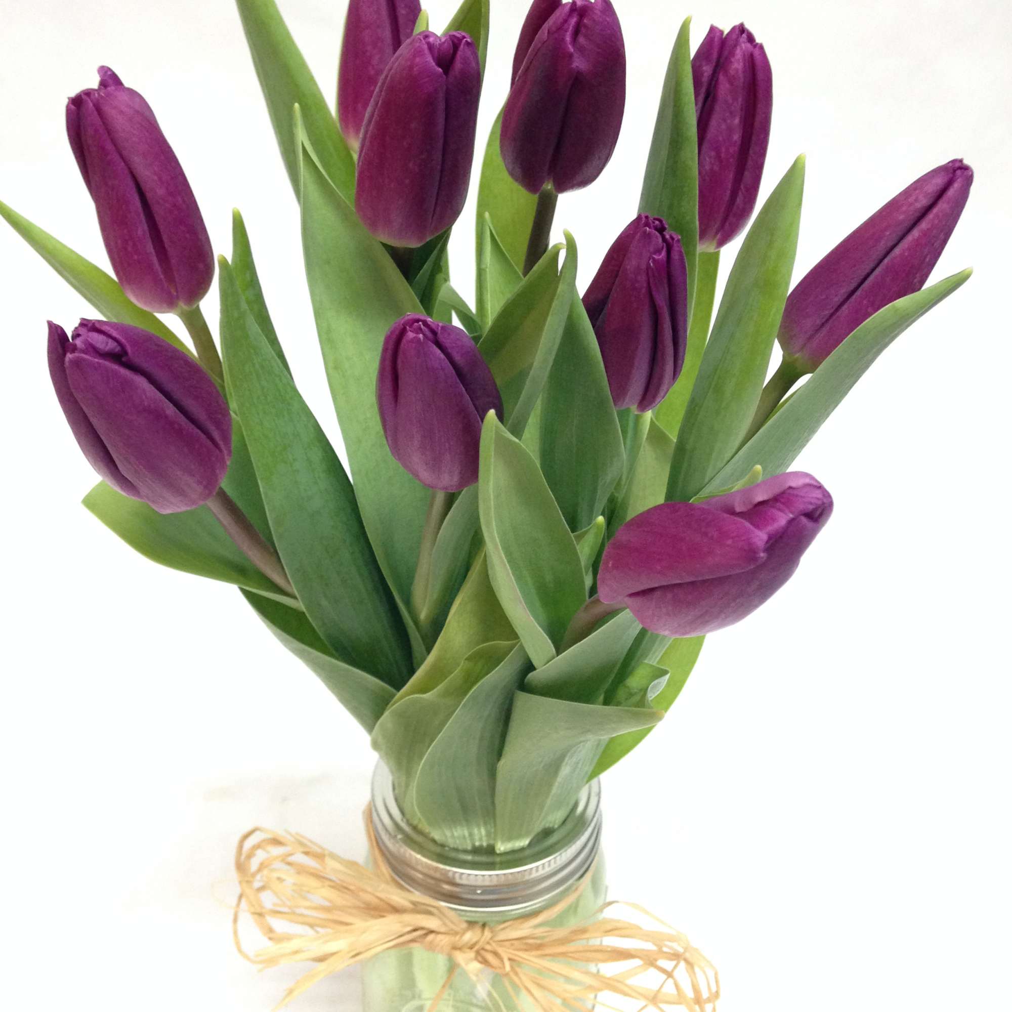 Purple tulips in a glass jar tied with raffia
